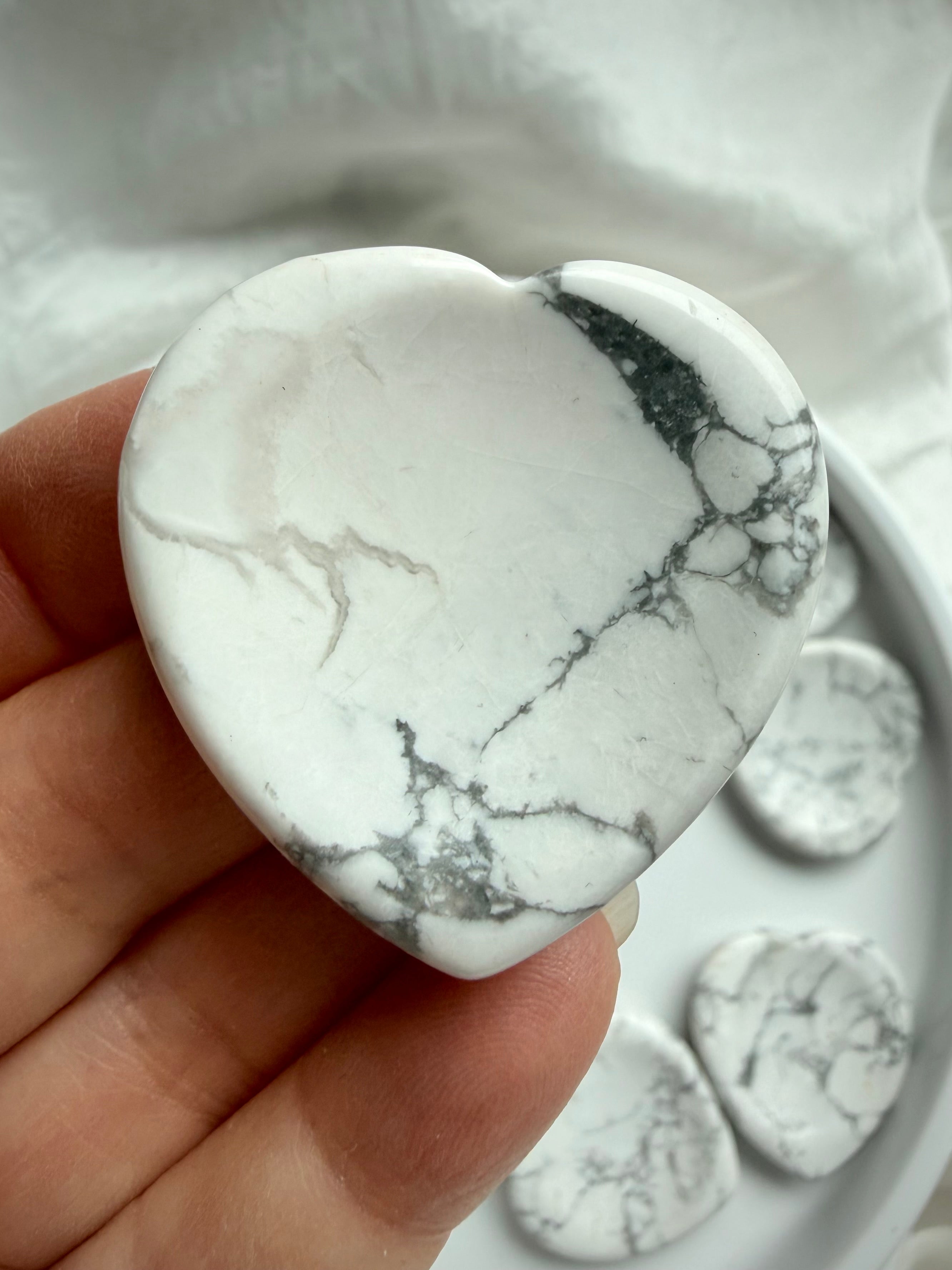 Howlite heart worry stone crown chakra crystal for calm and peaceful awareness, held in hand