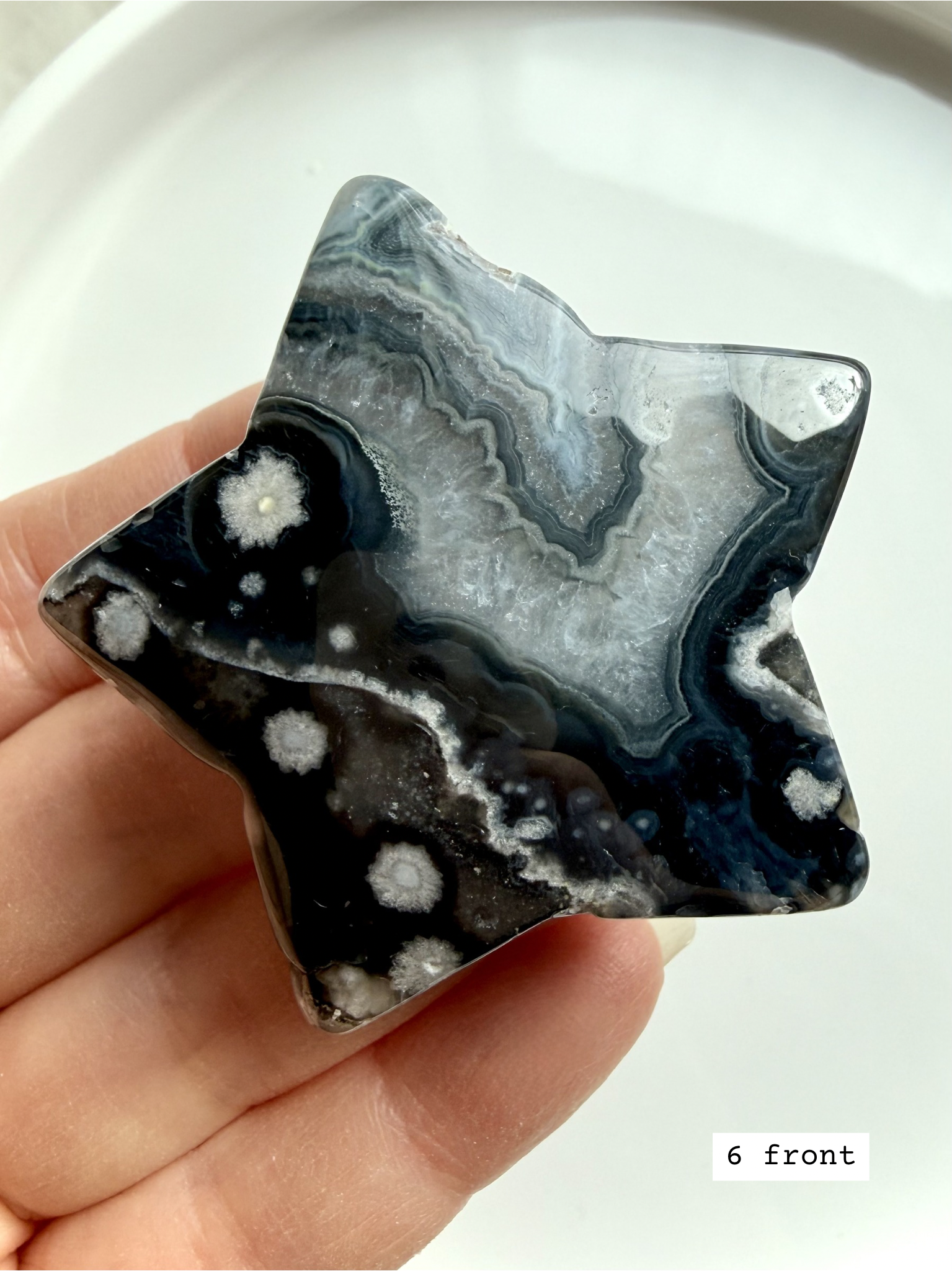 black flower agate star carving #6 front showing detailed petal-like inclusions and polished finish