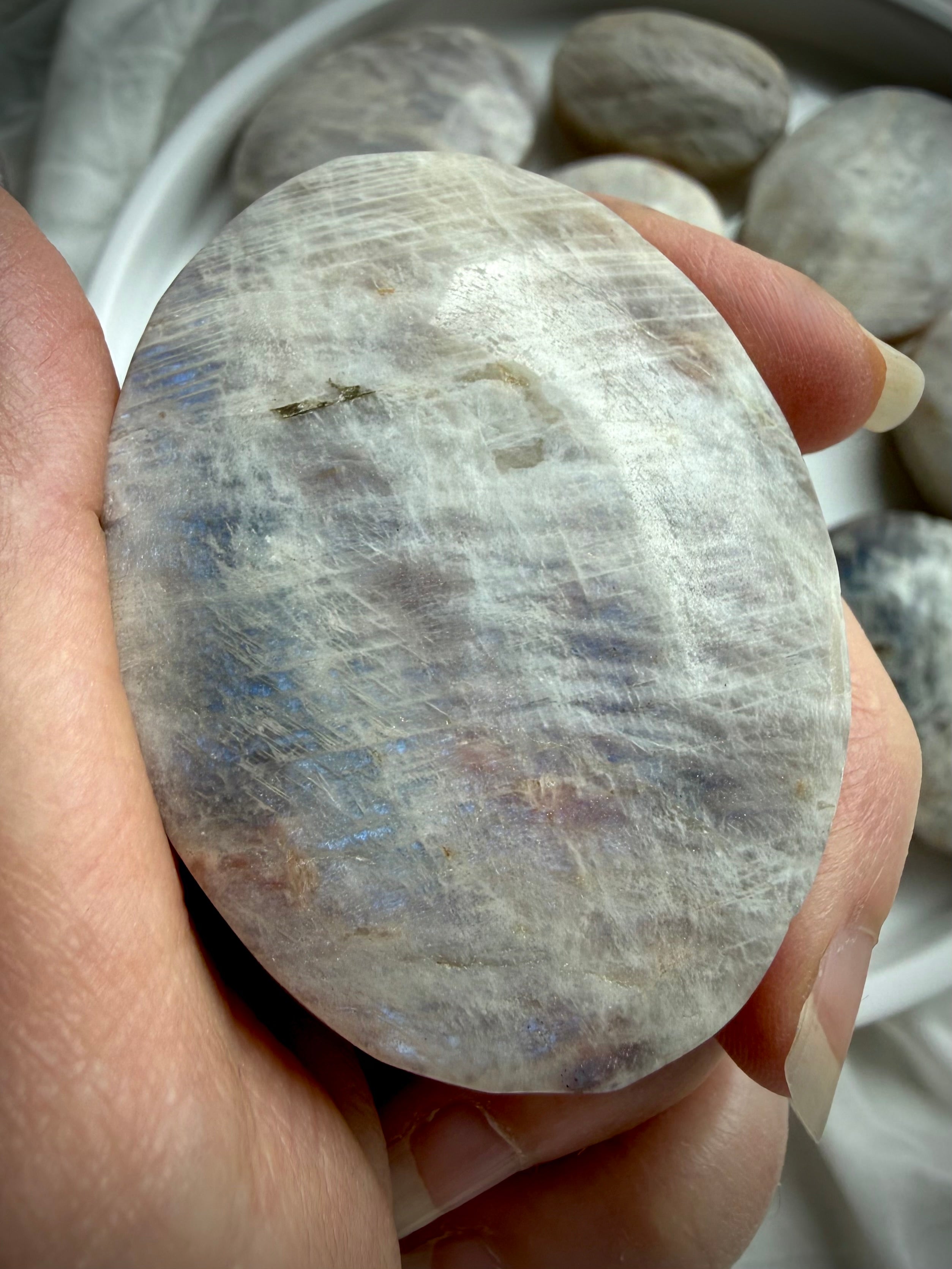 belomorite moonstone palm stone with blue flash, silvery shimmer, and natural sunstone inclusions in feldspar matrix