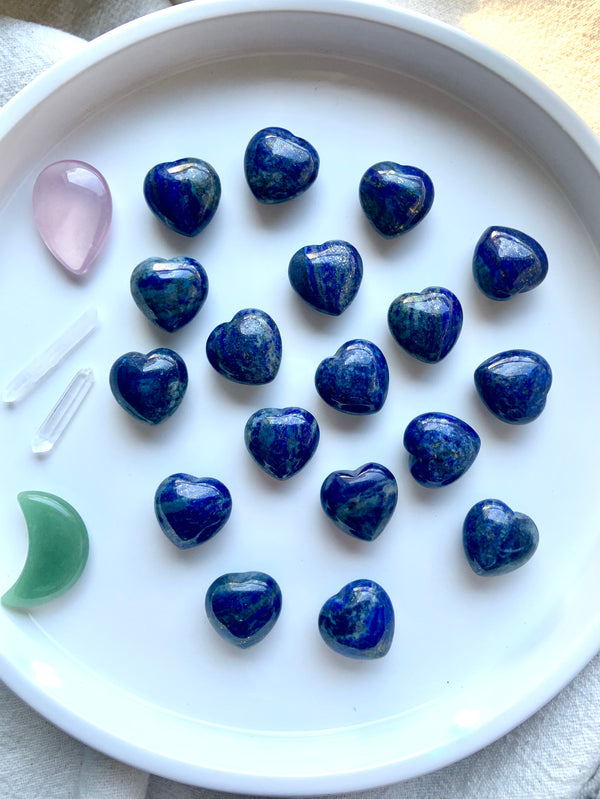 our mini sized, blue Lapis Lazuli Hearts shown on a white plate with some other crystal shapes as accents