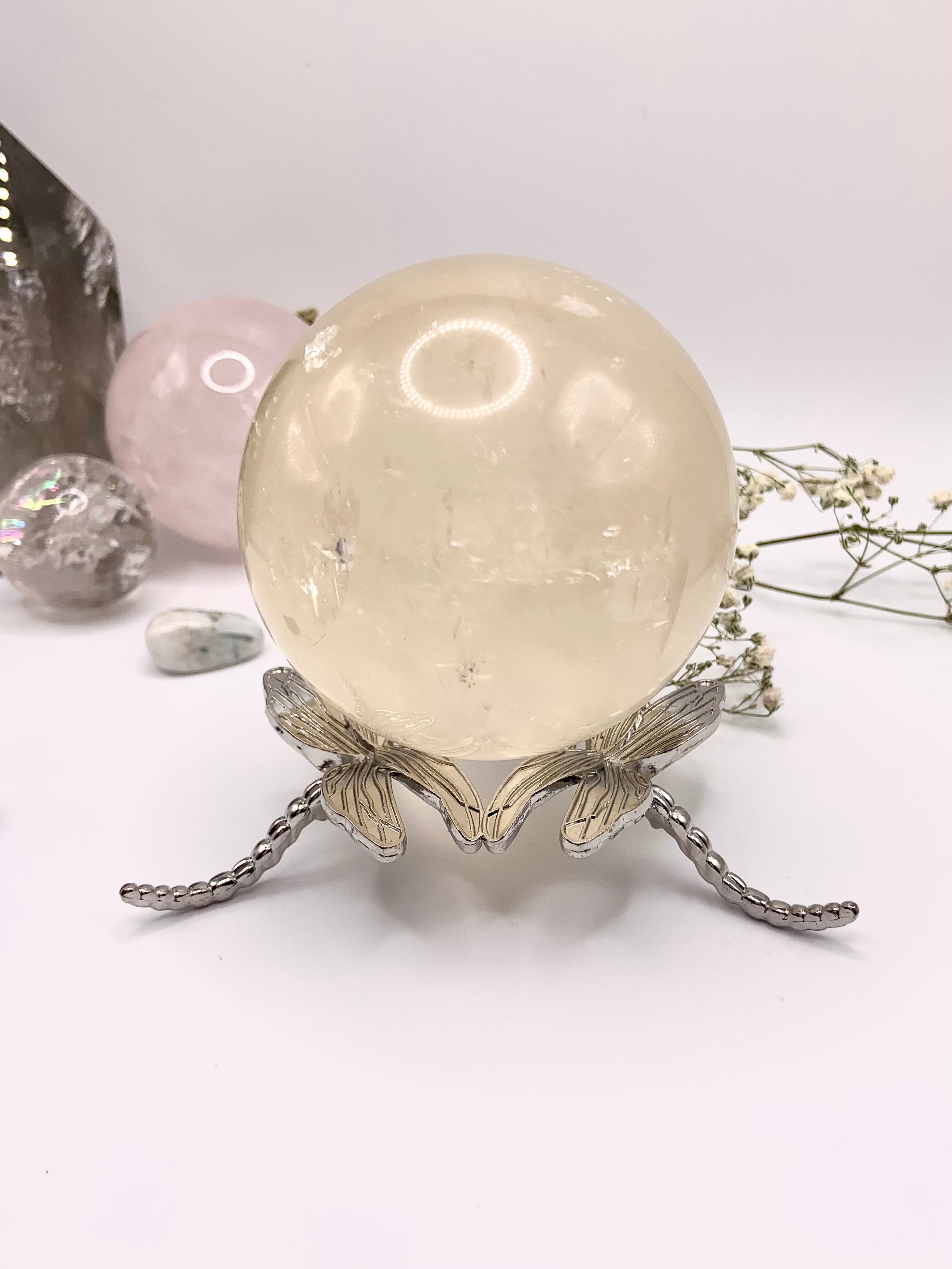 The larger dragonfly crystal sphere holder shown with a 72mm honey calcite sphere