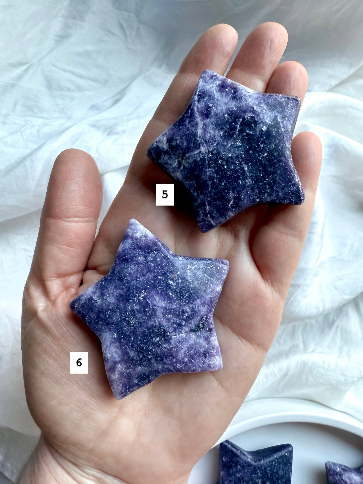 Hand holding two Lepidolite chunky star crystals, numbered for selection, purple and lavender polished carvings for emotional healing.