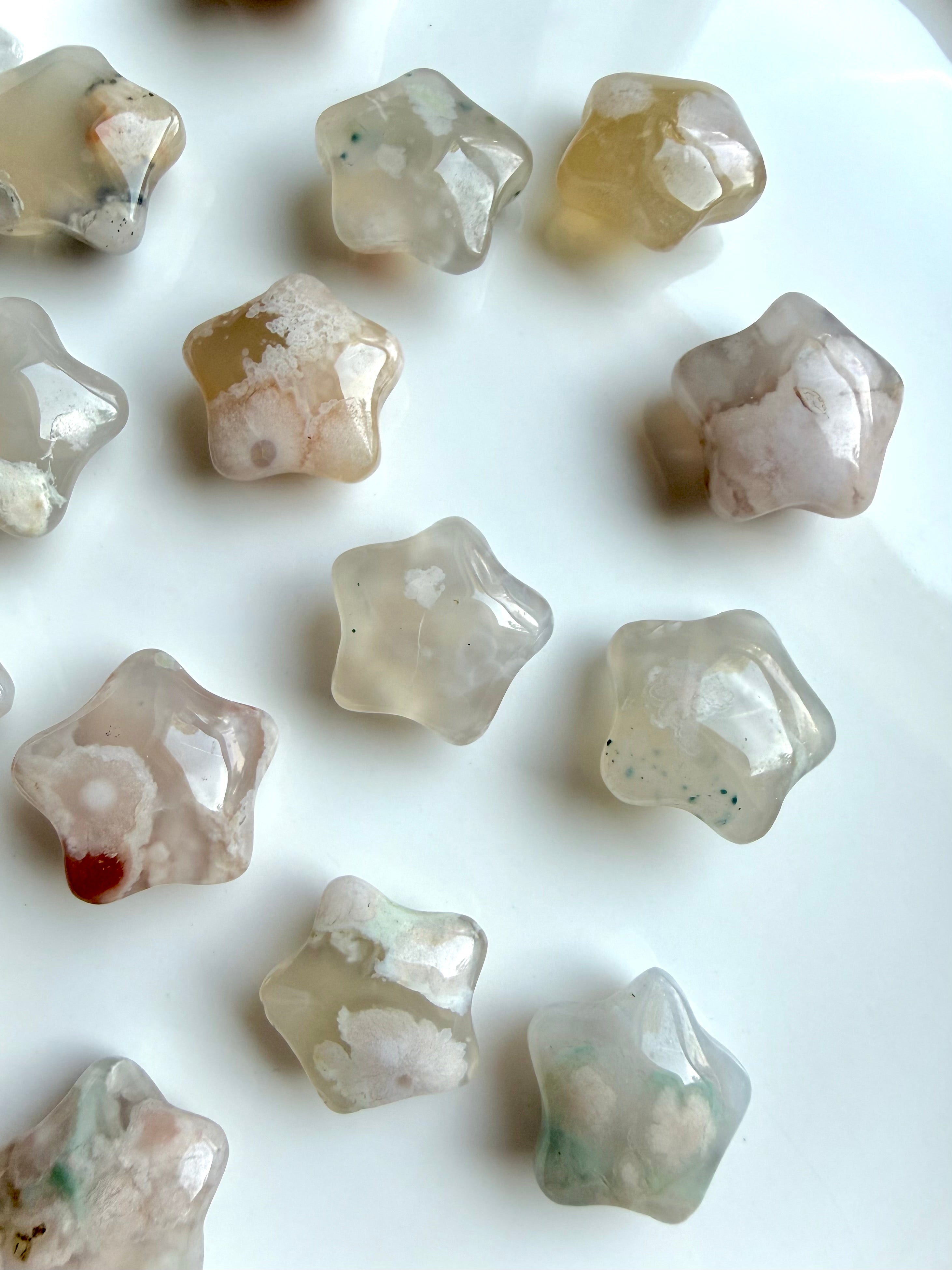 overhead view of mini Flower Agate starfish carvings displaying variation in color, pattern, and floral formations