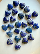 Mini Lapis Lazuli heart carvings showing deep royal blue stone with natural white calcite and gold pyrite inclusions, polished crystal hearts for wisdom and truth