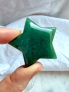 Close-up Green Aventurine star carving held in hand with rich green color, natural inclusions, and subtle aventurescence