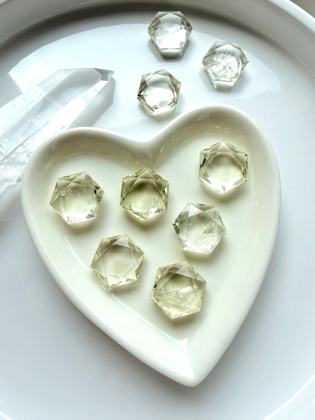 Mini Citrine hexagon crystals displayed in a white heart dish for abundance, manifestation, and crystal grids