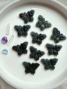 Overhead view of a tray of Wuji jade butterfly crystal carvings made from natural Guatemalan jade gemstone