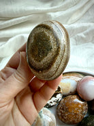 Polished Ocean Jasper palm stone with earthy green and golden brown coloring, natural texture, and mineral inclusions