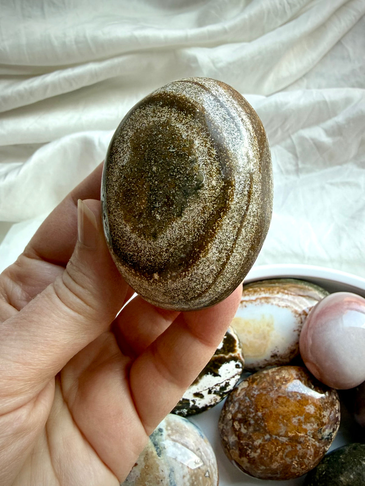 Polished Ocean Jasper palm stone with earthy green and golden brown coloring, natural texture, and mineral inclusions