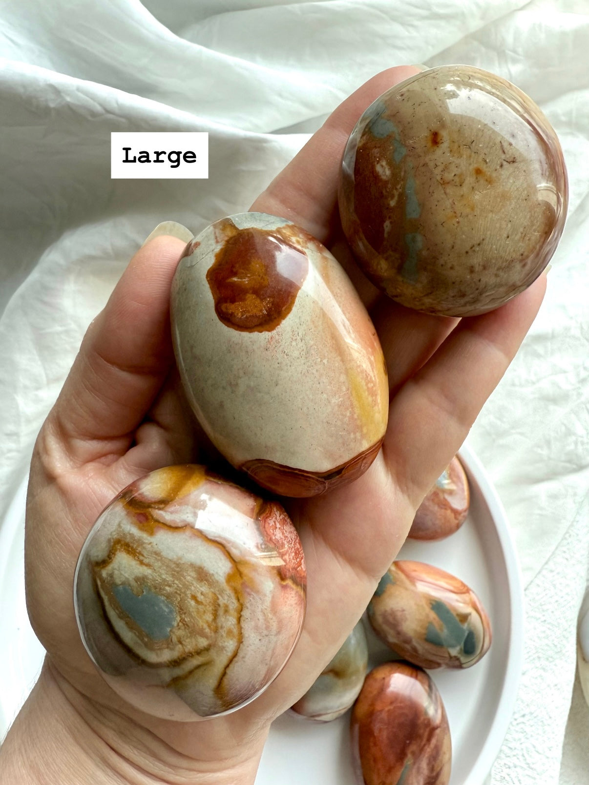 Large Polychrome Jasper palm stone shown in hand, with earthy color swirls & grounding energy.