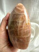 Side view of Peach Moonstone freeform display piece showing natural stone patterns & peachy shimmer