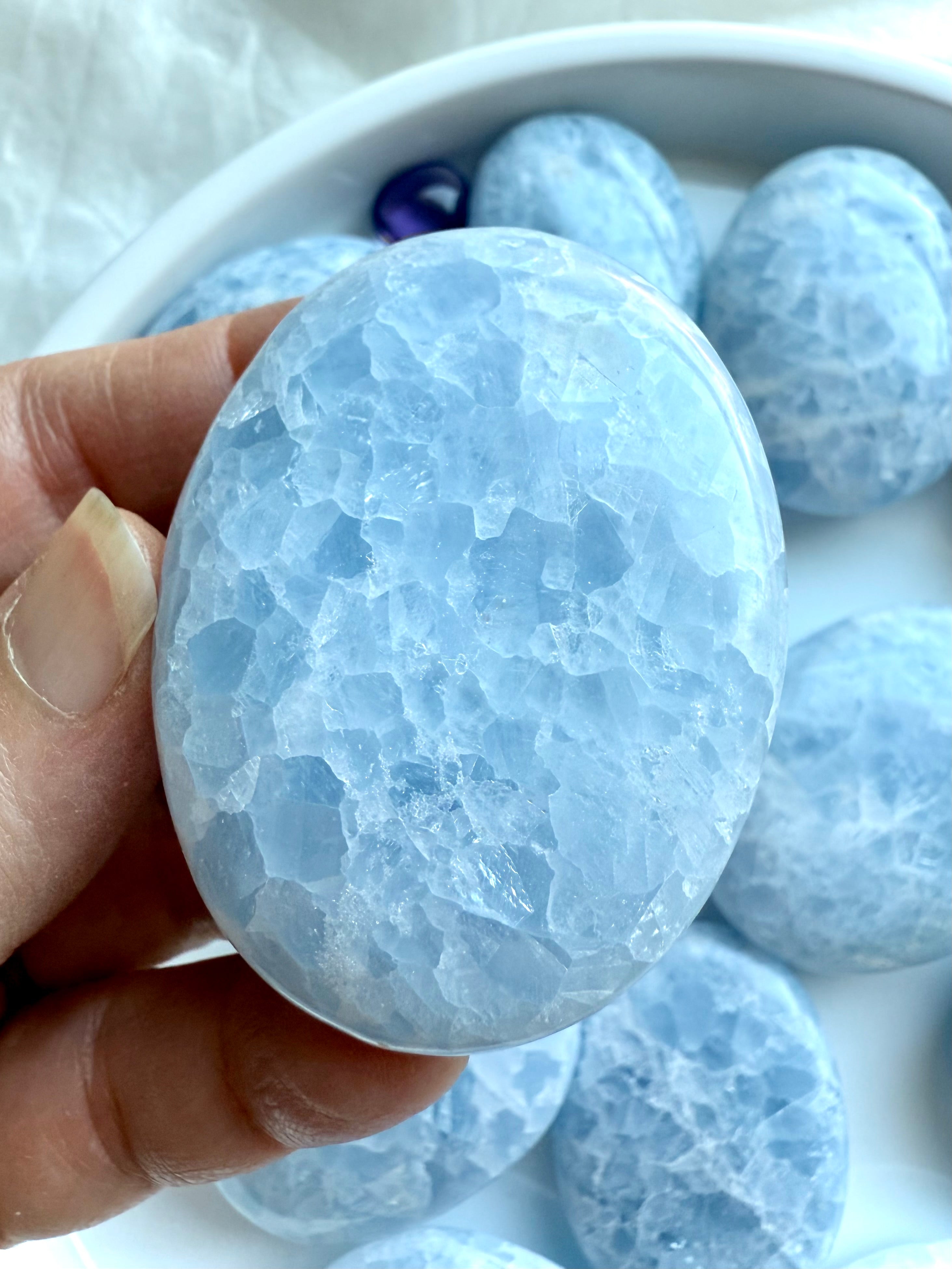 Detailed view of polished Blue Calcite palm stone showing natural white marbling and sparkling inclusions
