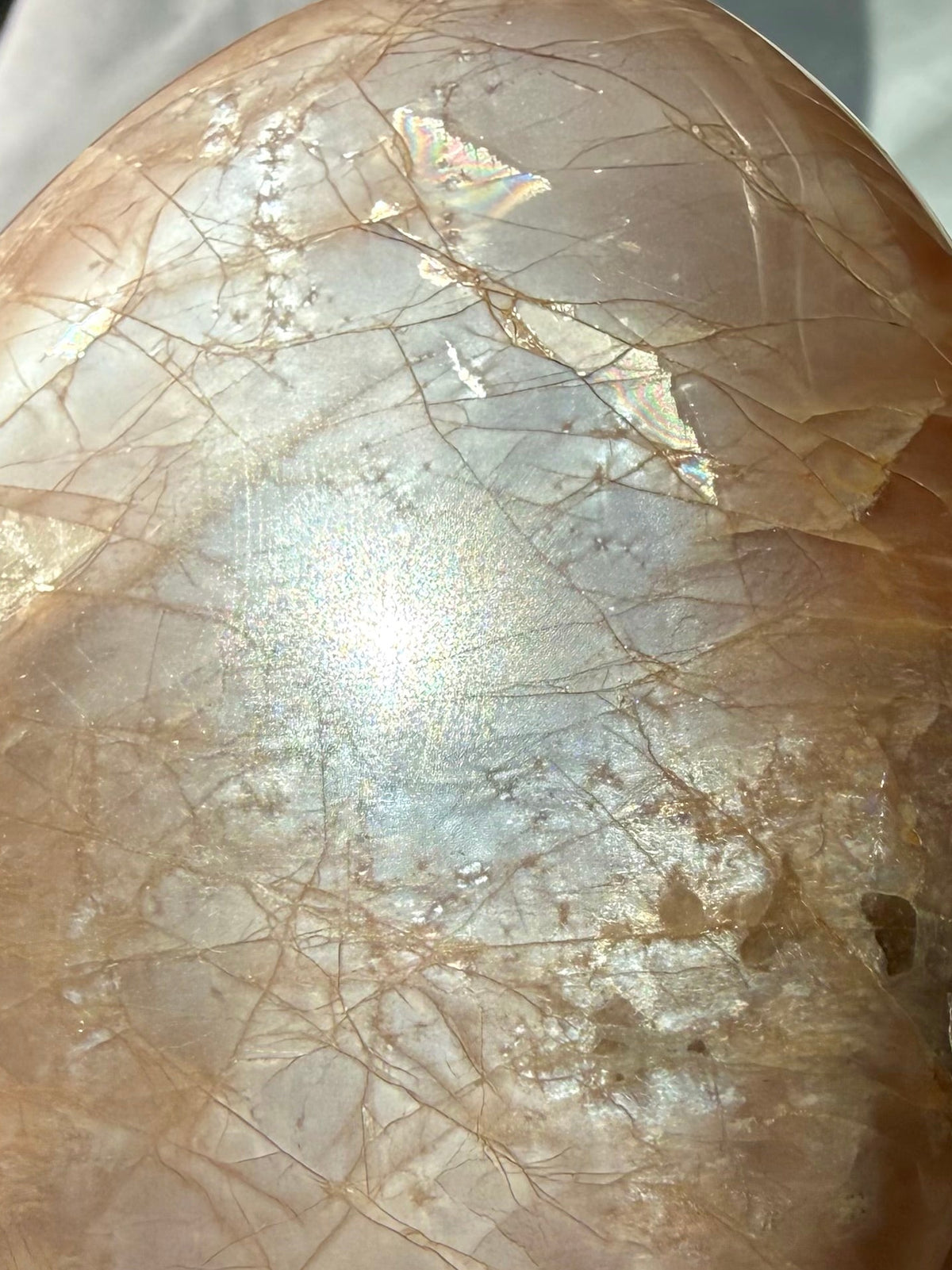 Close-up Peach Moonstone freeform showing luminous silver glow, golden Sunstone shimmer and warm peach feldspar tones