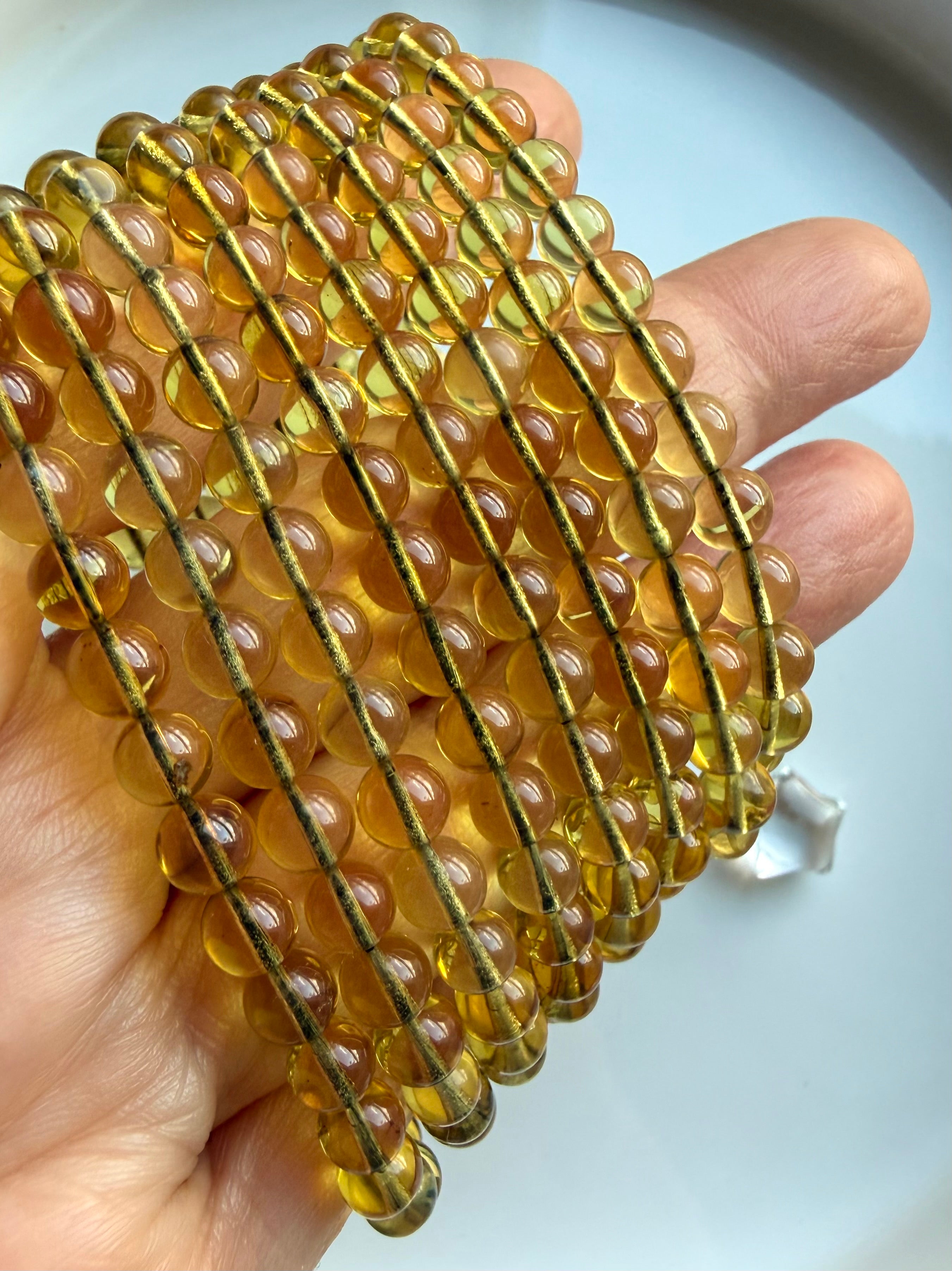 Stacked Indonesian blue amber bracelets showing translucent golden amber beads