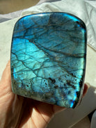 Blue flash Labradorite display crystal showing luminous aqua-blue color and natural internal patterns