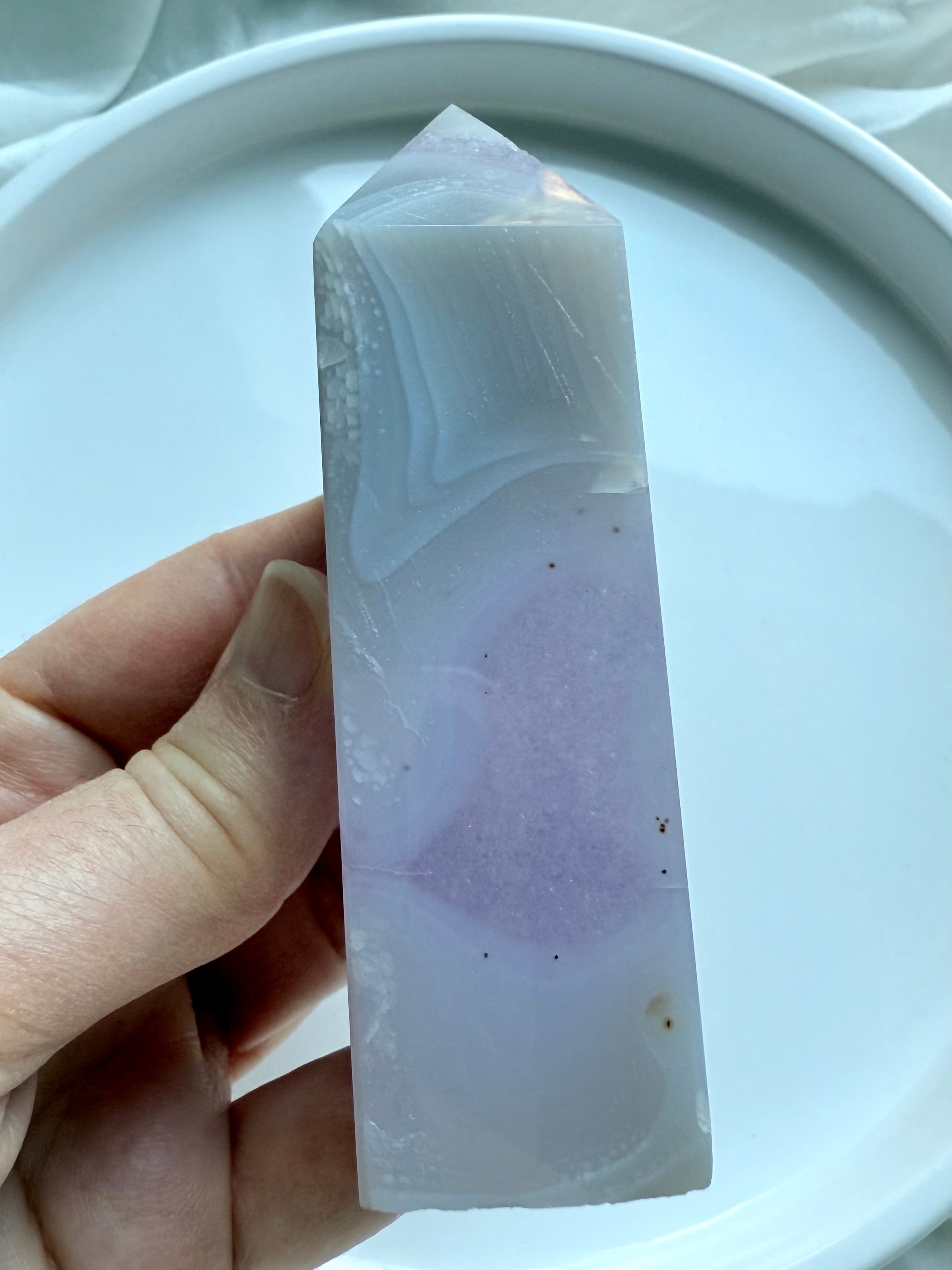 Close-up of polished Amethyst Tower with quartz inclusion and soft purple hues