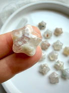 close-up of Flower Agate starfish carvings featuring delicate blossom inclusions and polished crystal surfaces