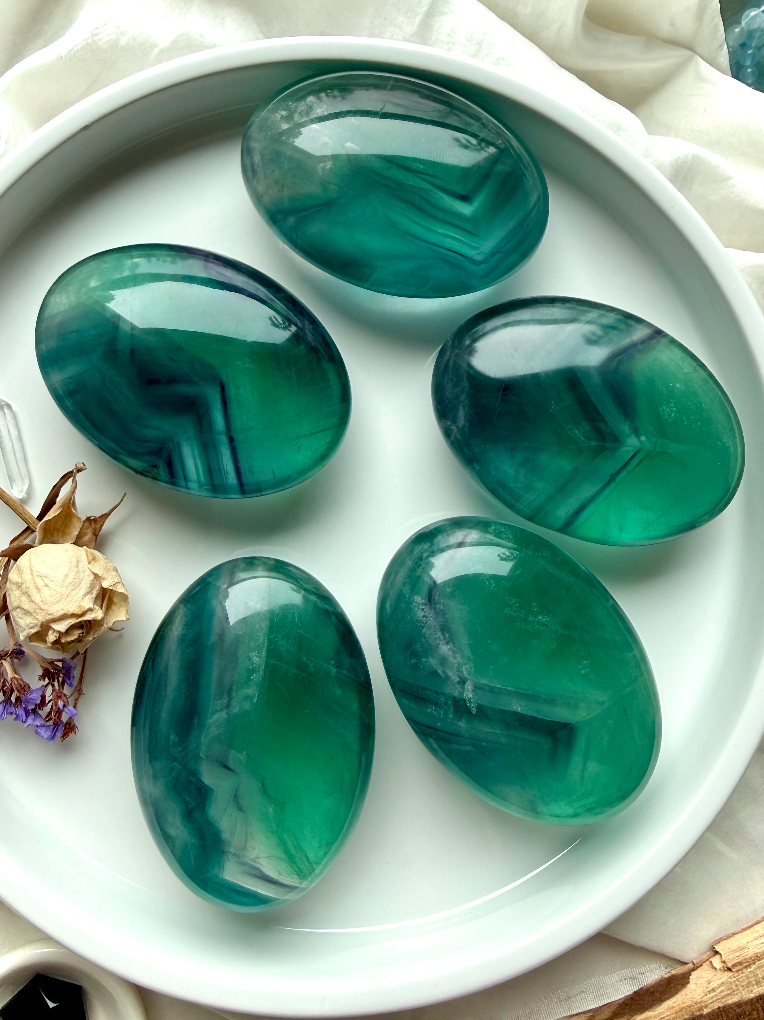 Large polished teal fluorite palm stones with bold blue green bands and natural clarity-enhancing energy