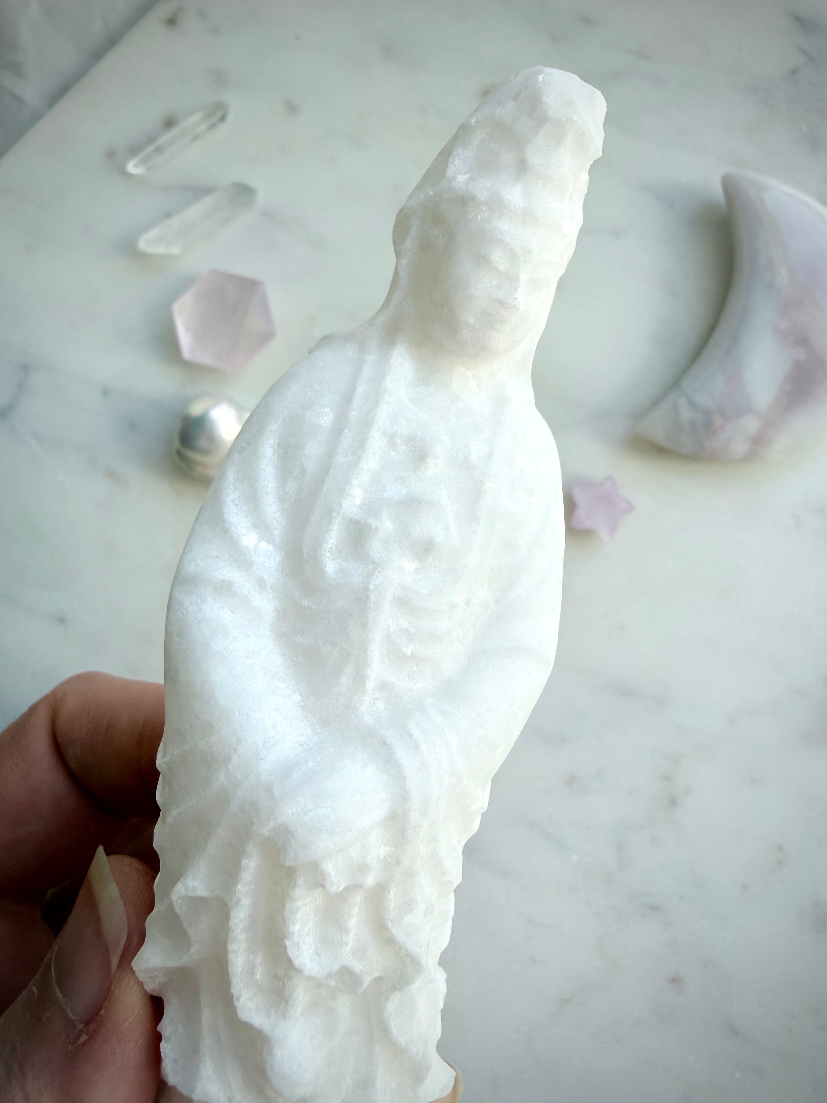 White Jade Quan Yin statue with lotus base displayed in a peaceful meditation setting