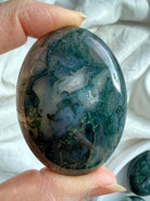 Natural moss agate palm stone with forest-like inclusions and soft green tones, calming crystal for emotional balance