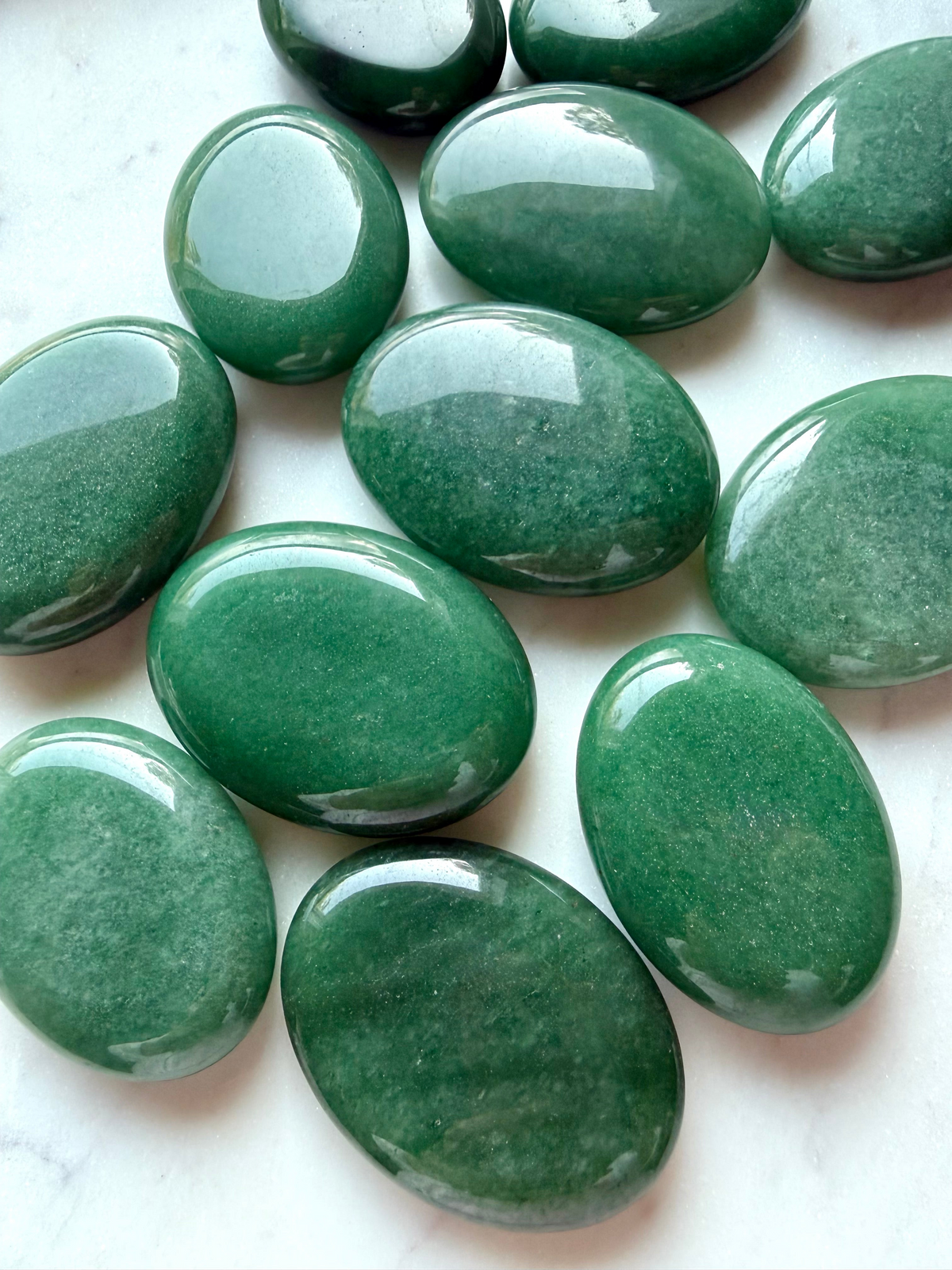 Natural Green Aventurine palm stones with smooth oval shapes, glossy polish, and varied shades of green