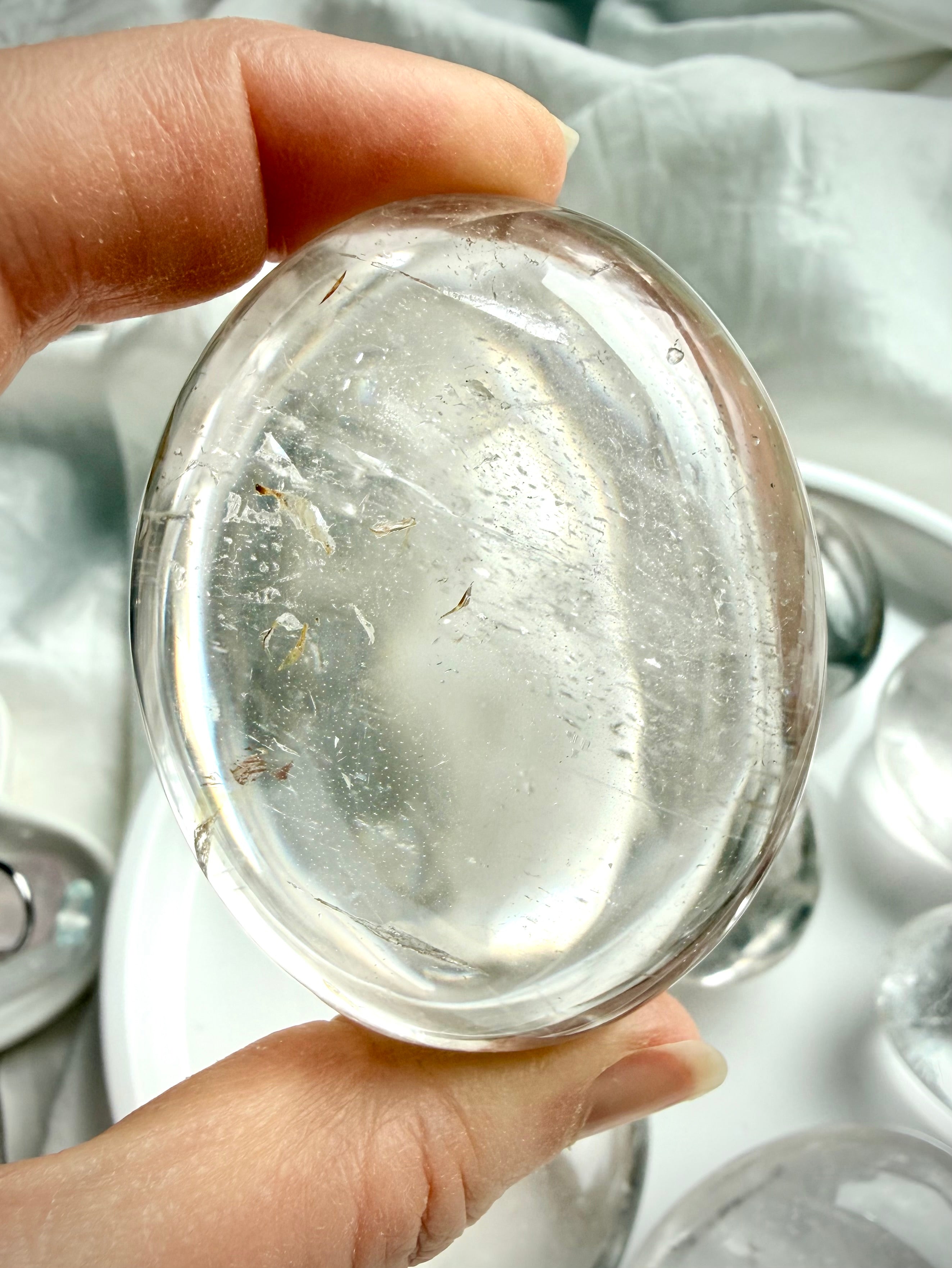 close up of a polished clear quartz crystal detail showing natural inclusions and light reflection