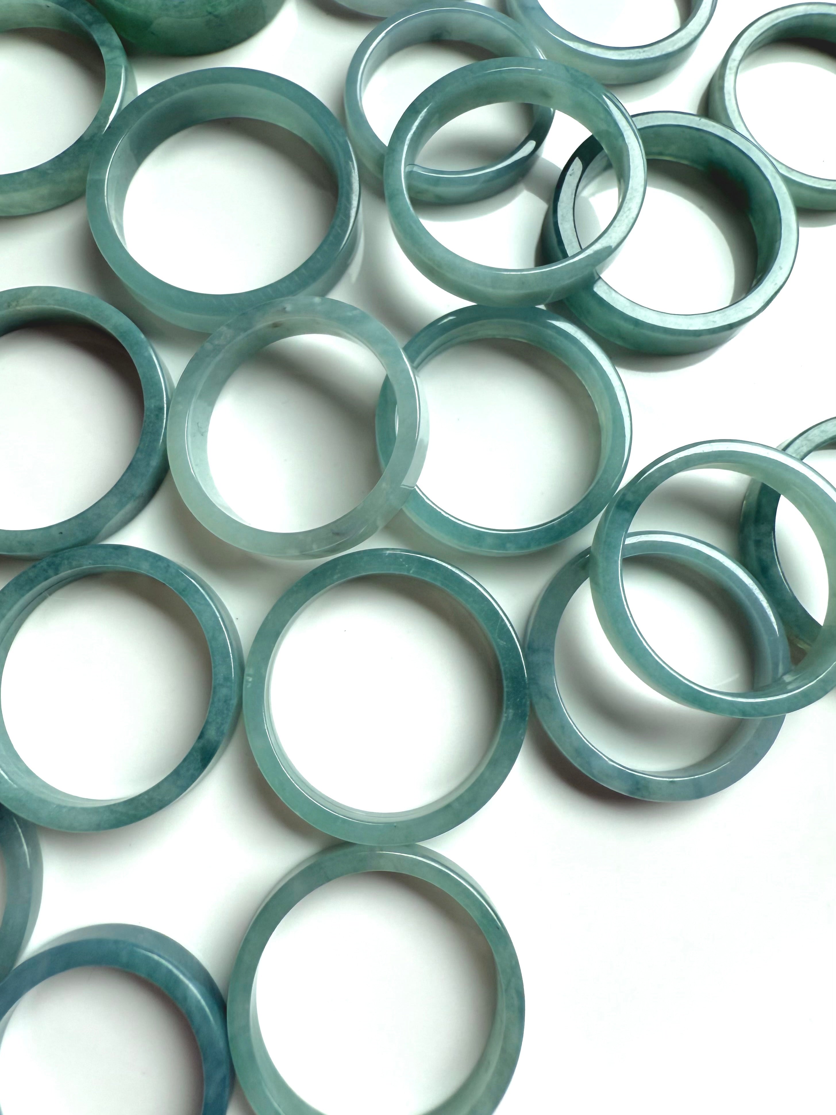 Overhead shot of Blue Water Jade flat rings arranged in a soft scattering for crystal healing display