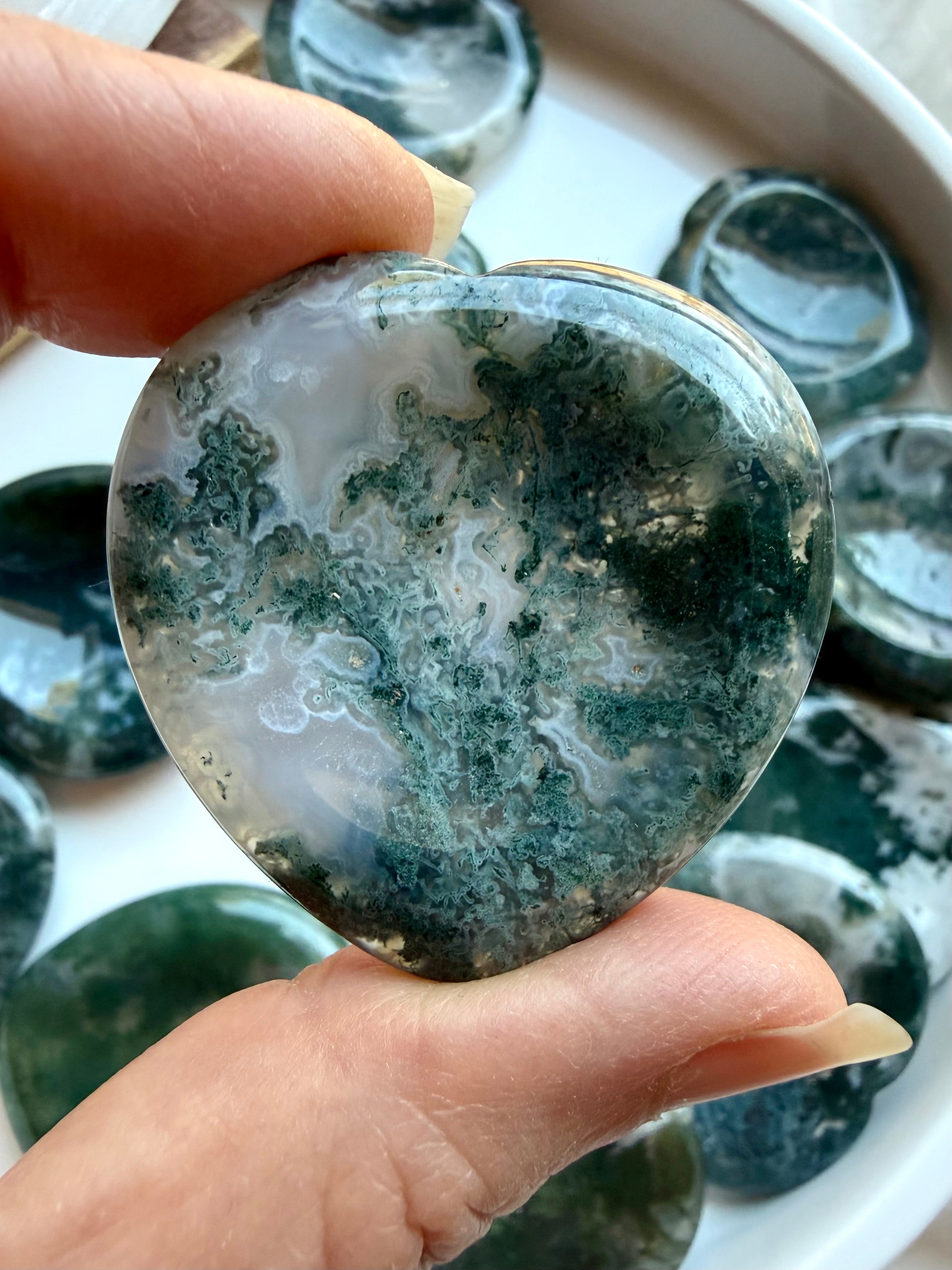 Moss Agate heart worry stone held in hand with rich moss inclusions and natural translucent quartz