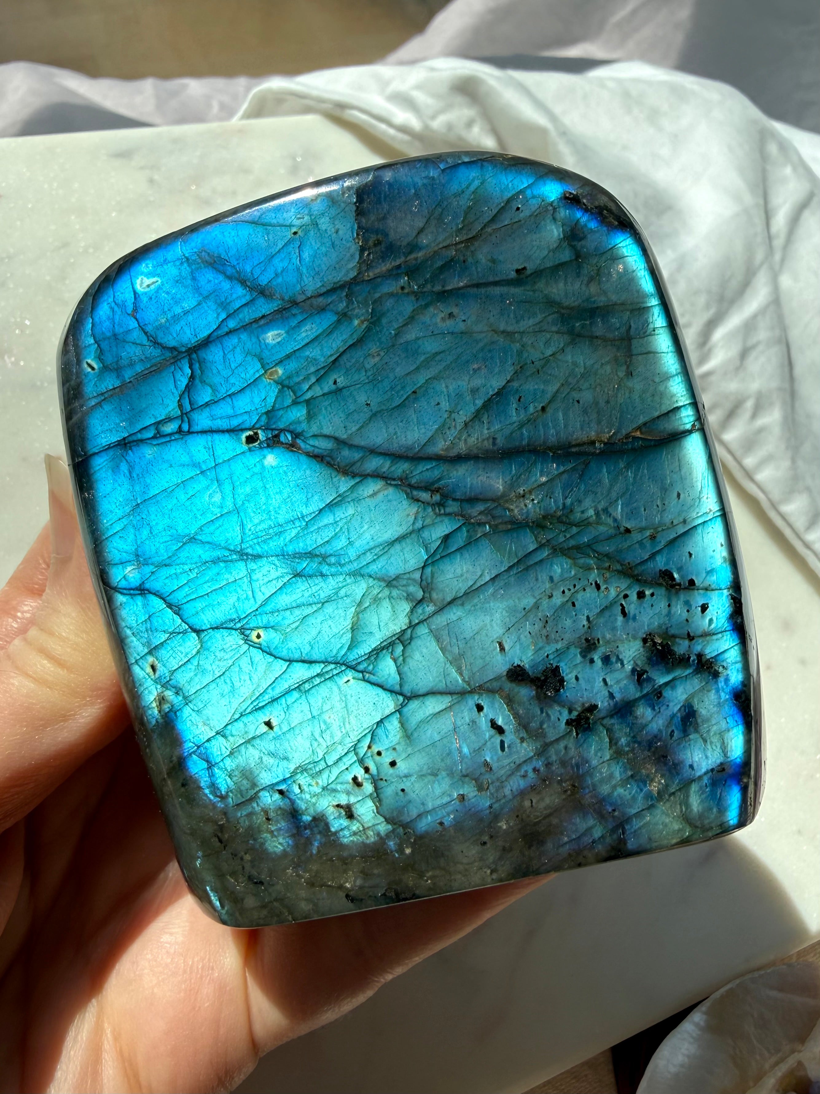 Polished Labradorite freeform with strong electric blue labradorescence shifting across the front