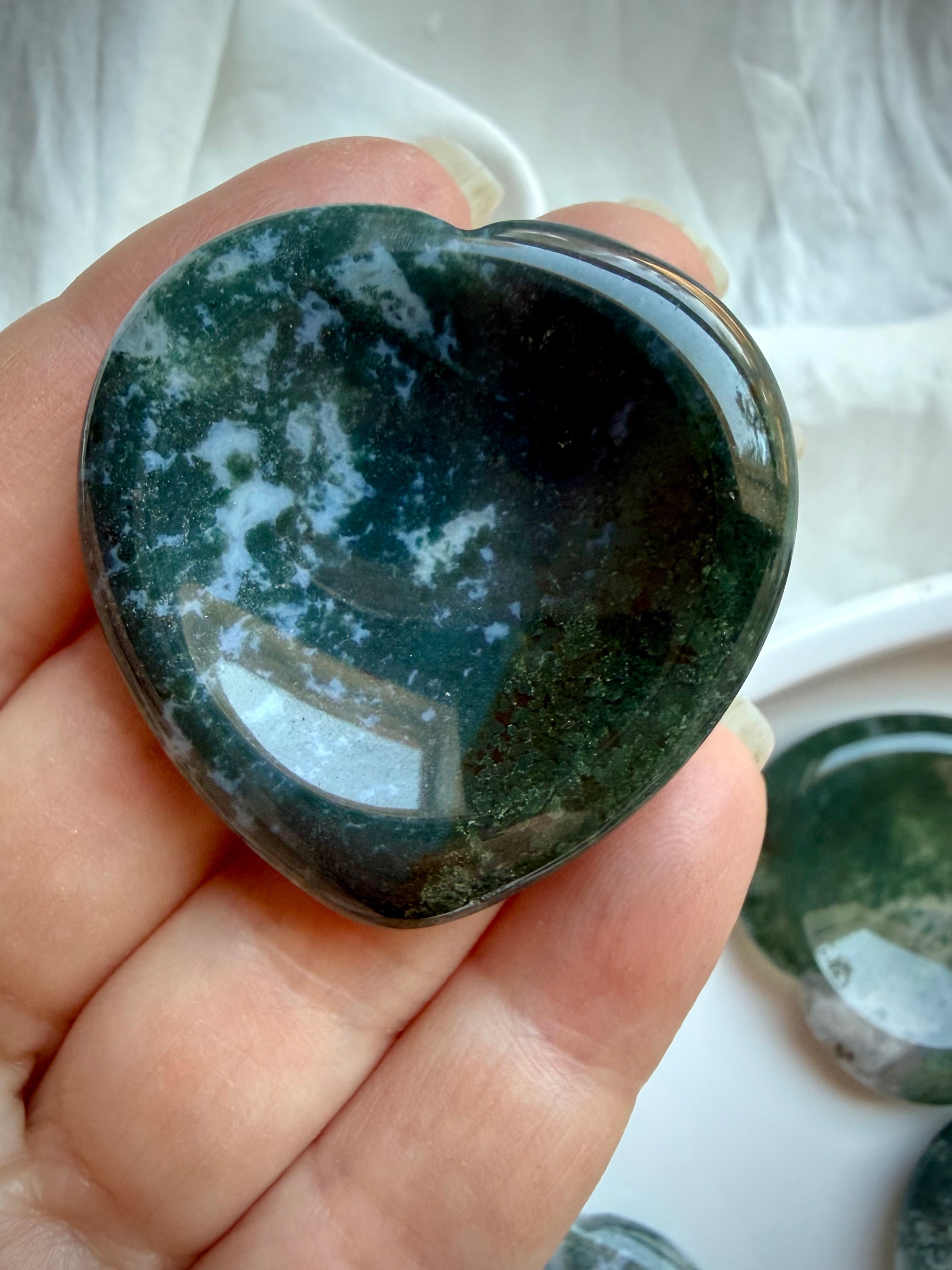 Moss Agate heart worry stone held in hand with dense forest green dendritic inclusions