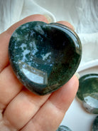 Moss Agate heart worry stone held in hand with dense forest green dendritic inclusions