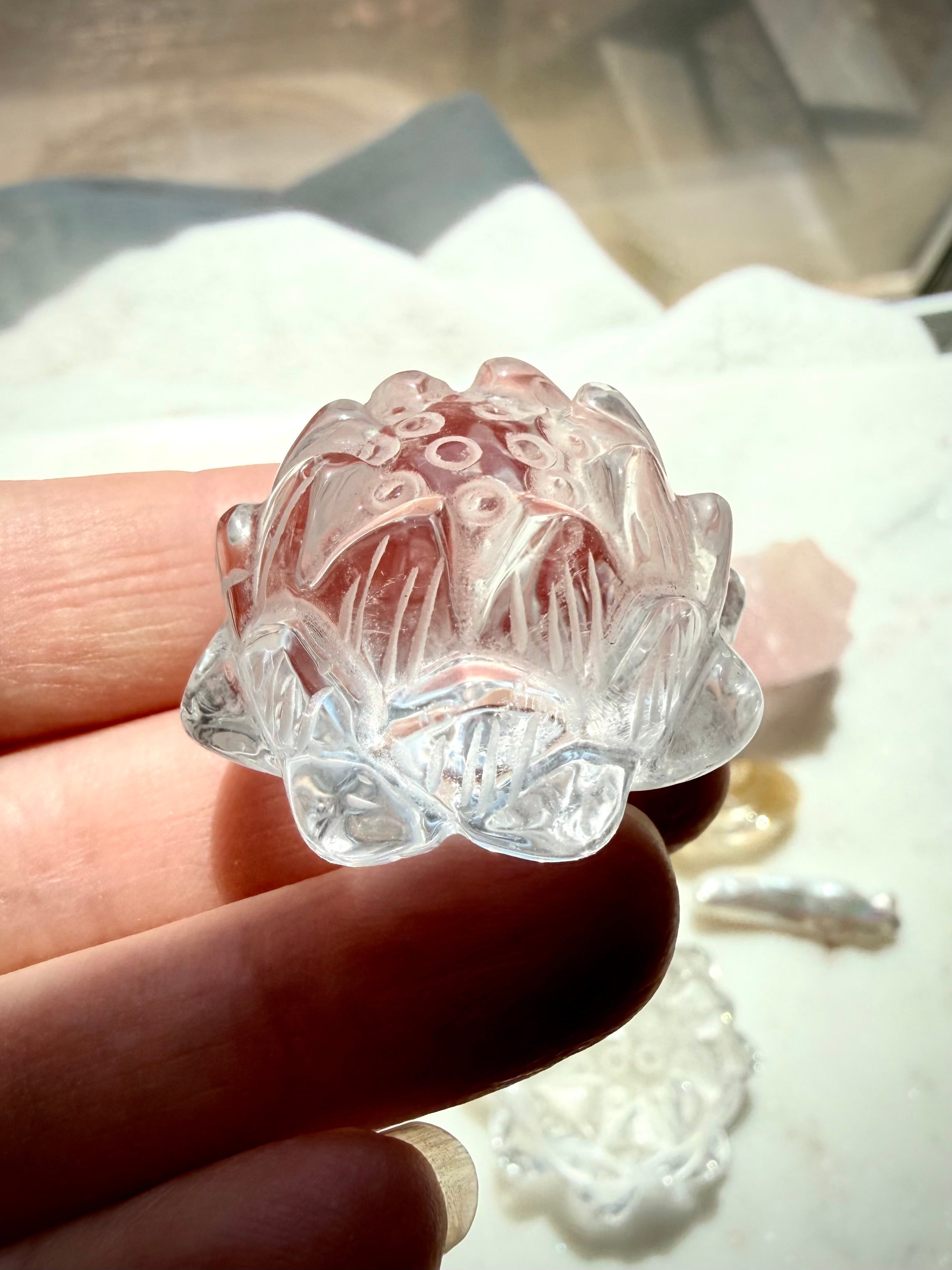 Clear Quartz lotus carving held in hand with luminous polished petals and natural internal veils