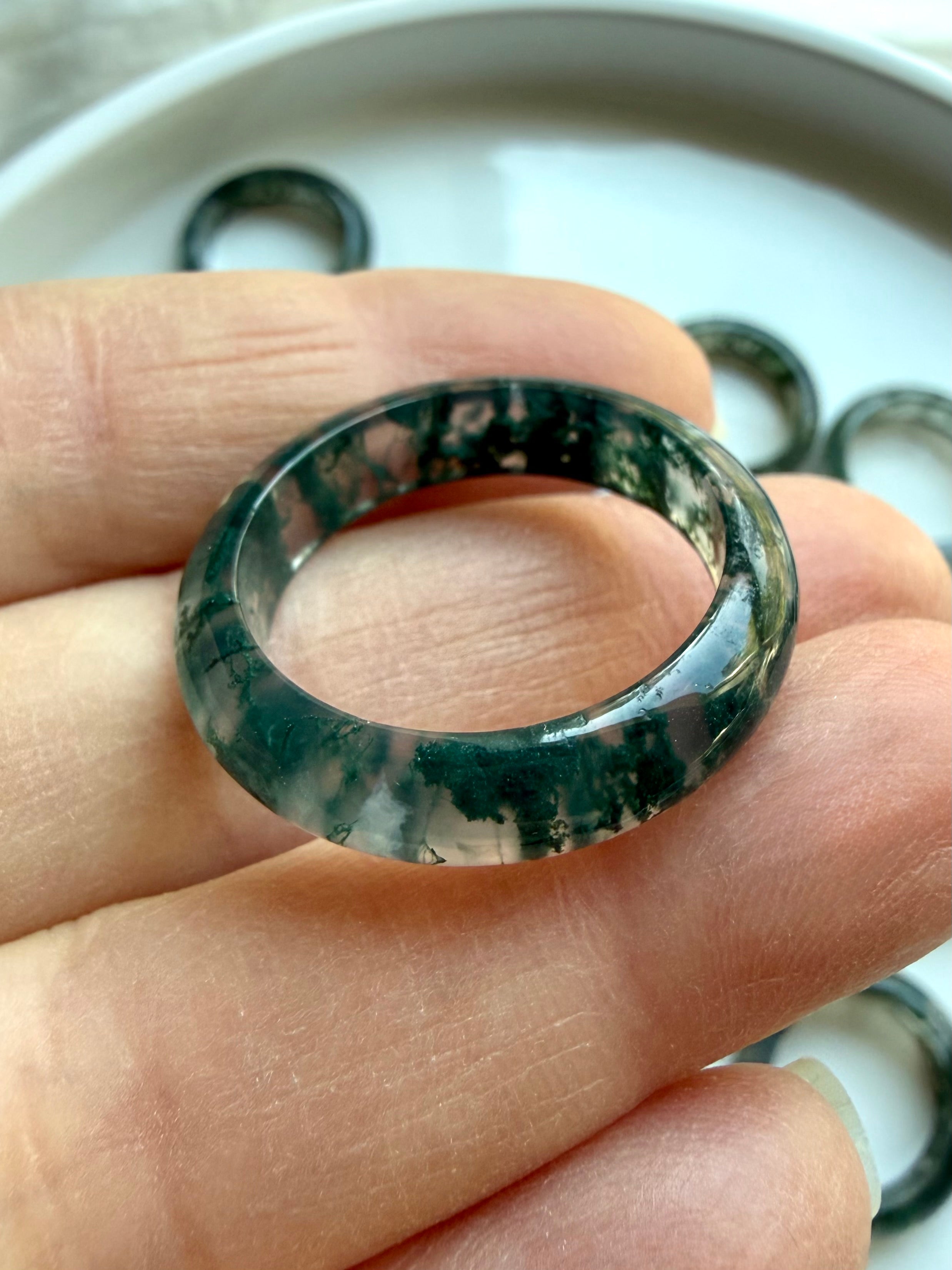 moss agate band ring on hand displaying varied natural patterns, crystal rings for growth stability and nature connection