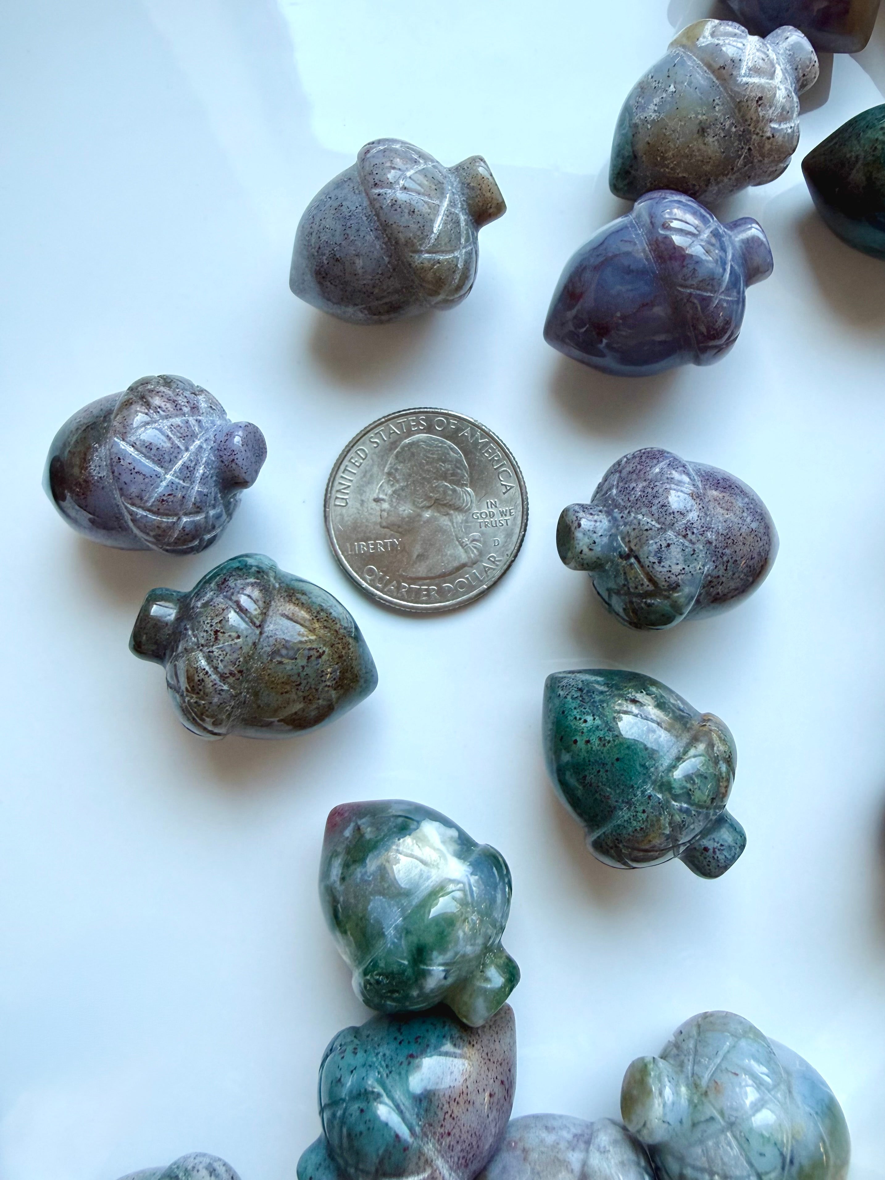 Mini Ocean Jasper acorn carvings with a US Quarter for scale, showing unique mottled, speckled and landscape-like patterns in assorted colors