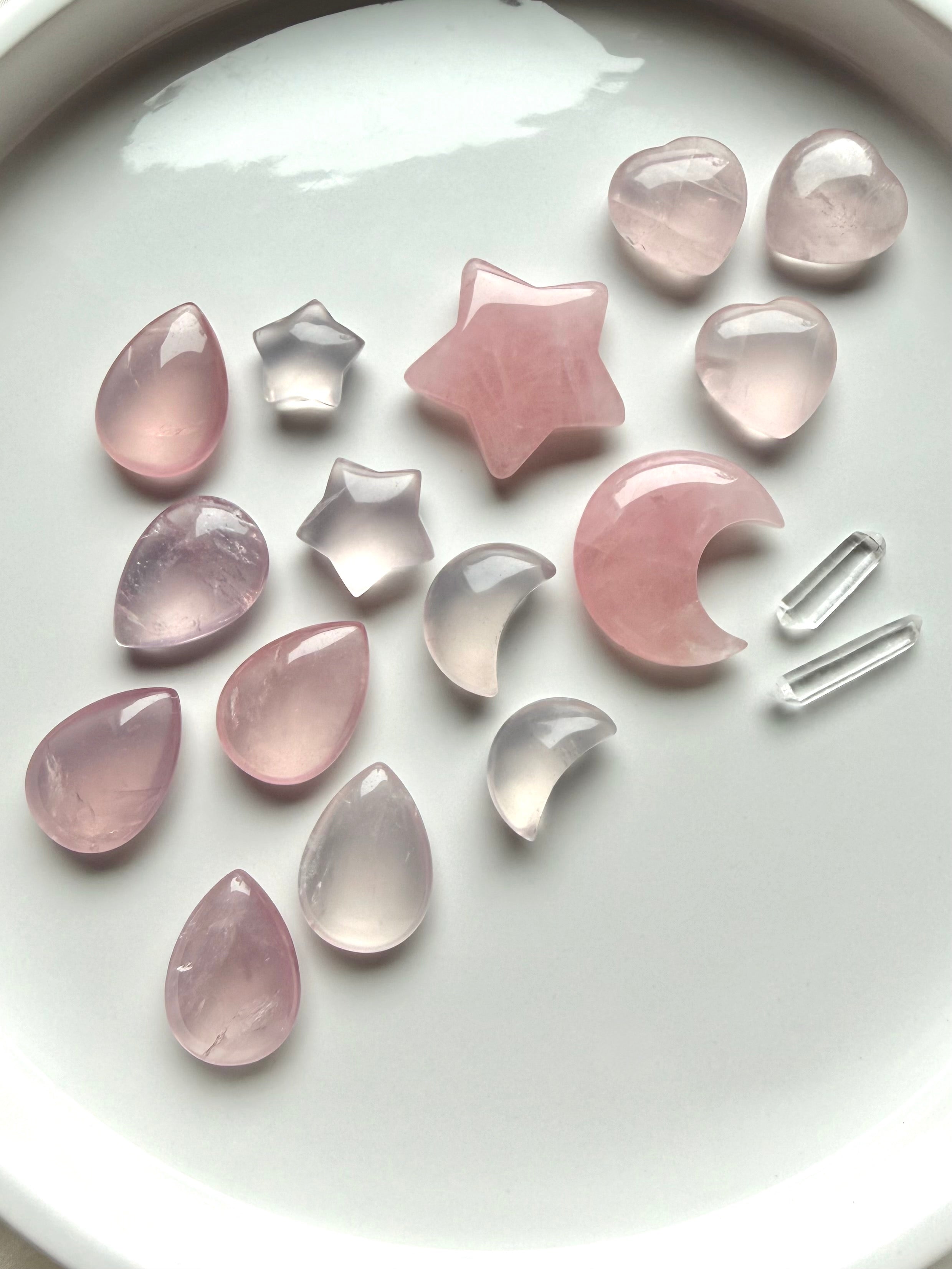 Rose Quartz crystal carvings in teardrops, hearts, moons and stars showing natural variations in pink color, size and transparency