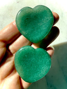green aventurine heart worry stone held in hand with smooth thumb indentation for meditation and stress relief
