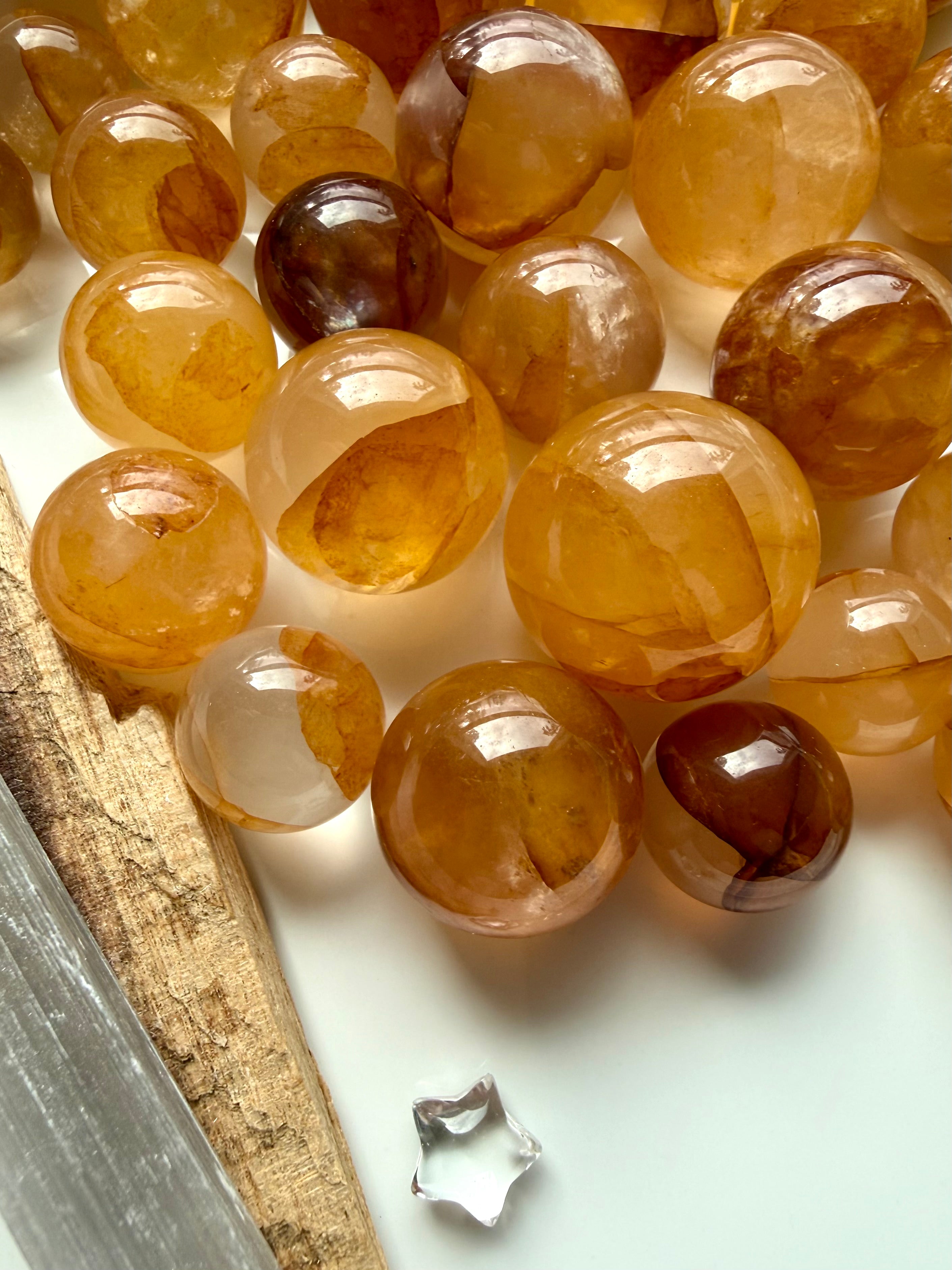 golden healer quartz mini spheres arranged on white surface with natural golden coloration