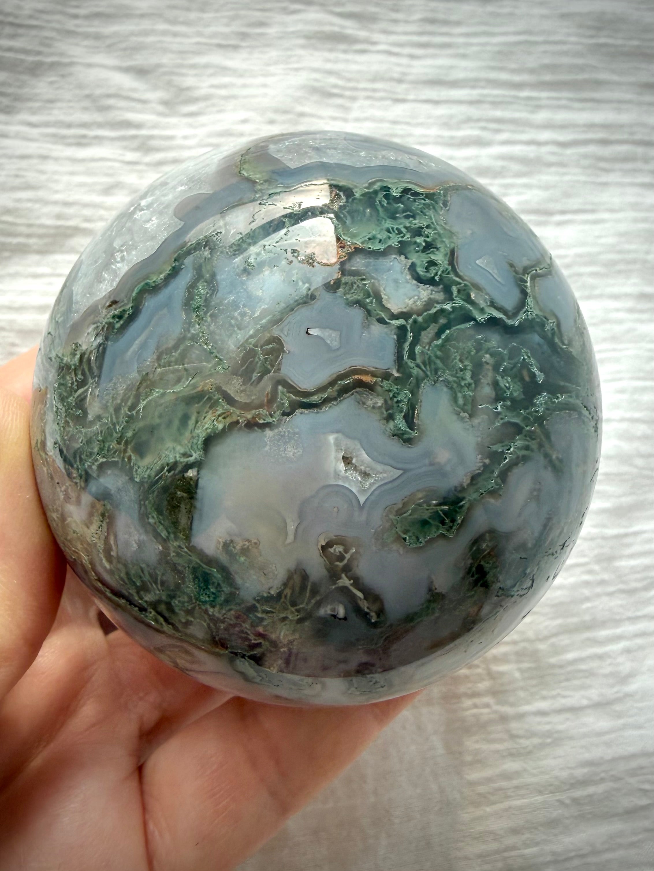 Polished Moss Agate crystal sphere with forest green dendrites, blue-gray agate banding and luminous translucent areas