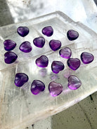 Angled view of mini Amethyst hearts on a selenite slab — heart-shaped crystals for clarity and connection