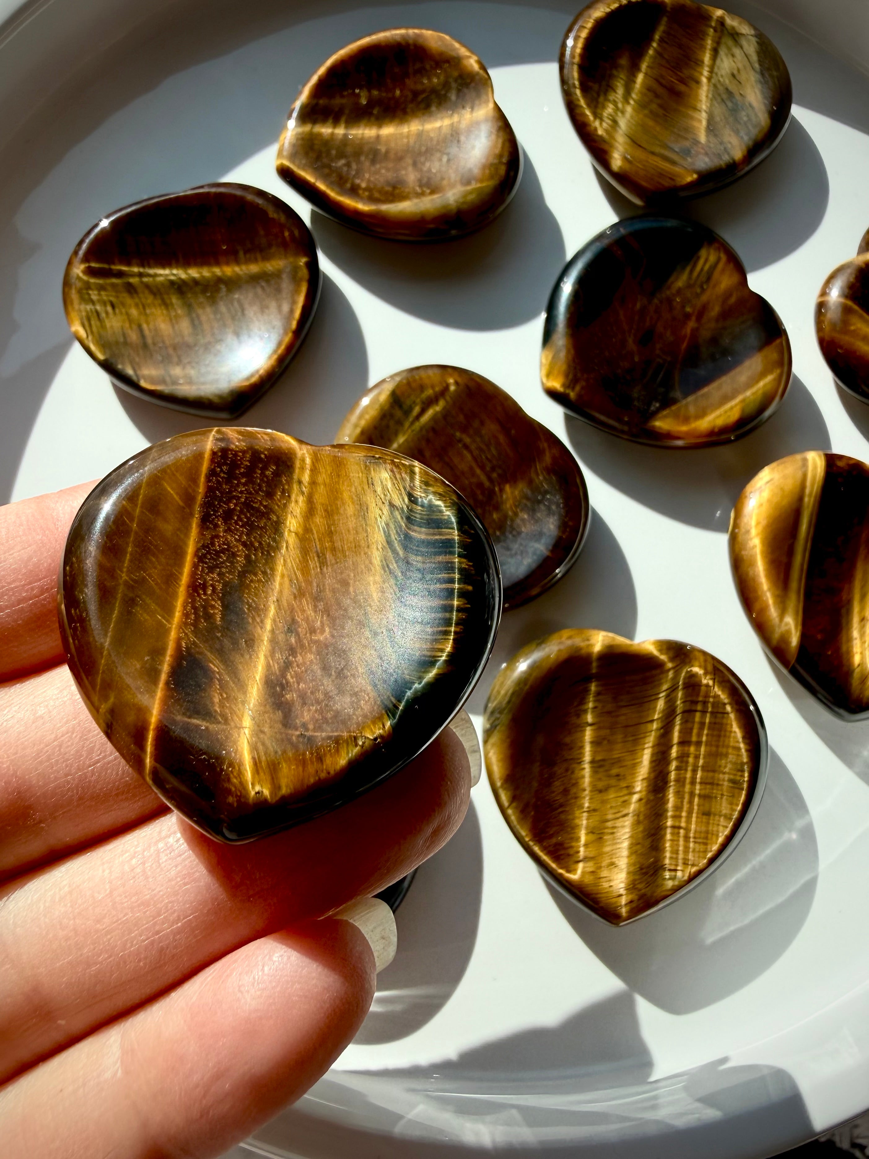 Tiger’s Eye heart worry stone with golden chatoyancy, natural brown banding, and polished thumb indentation for grounding and confidence