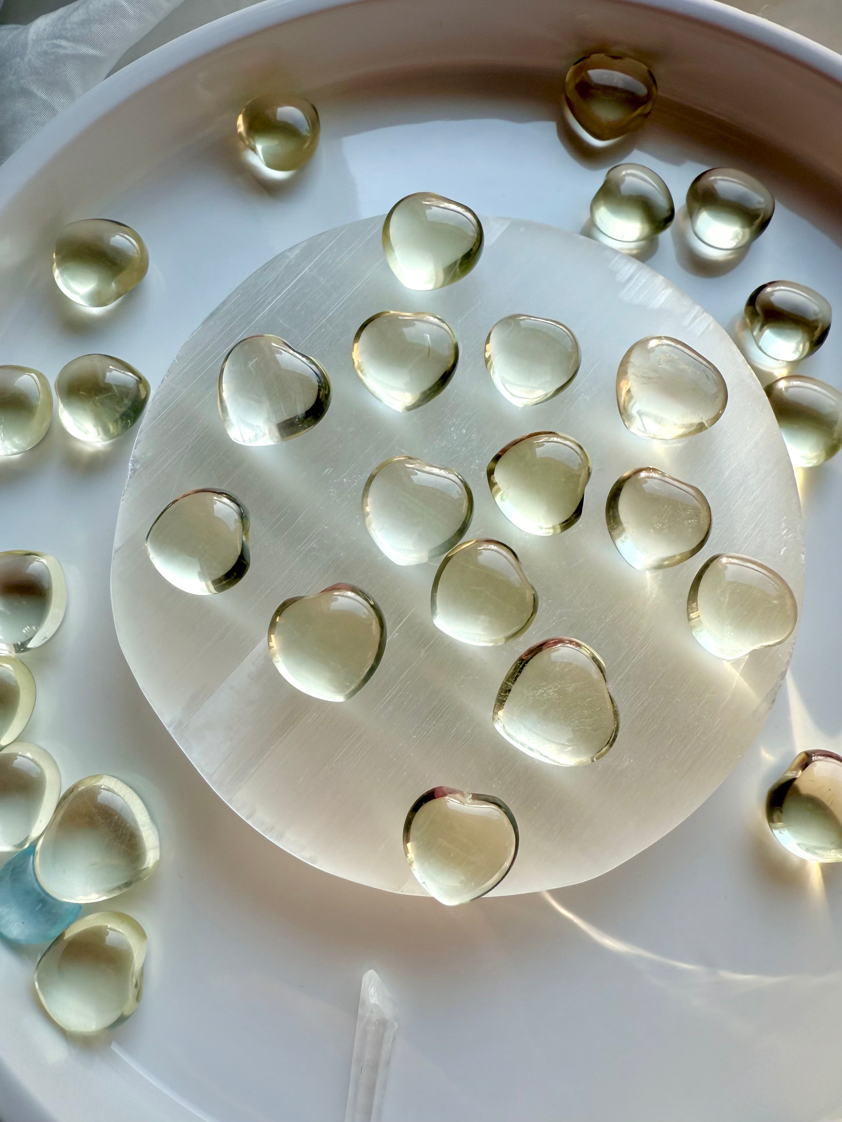 Mini Lemon Citrine heart crystals displayed on a selenite plate, small polished citrine hearts for joy and Solar Plexus energy