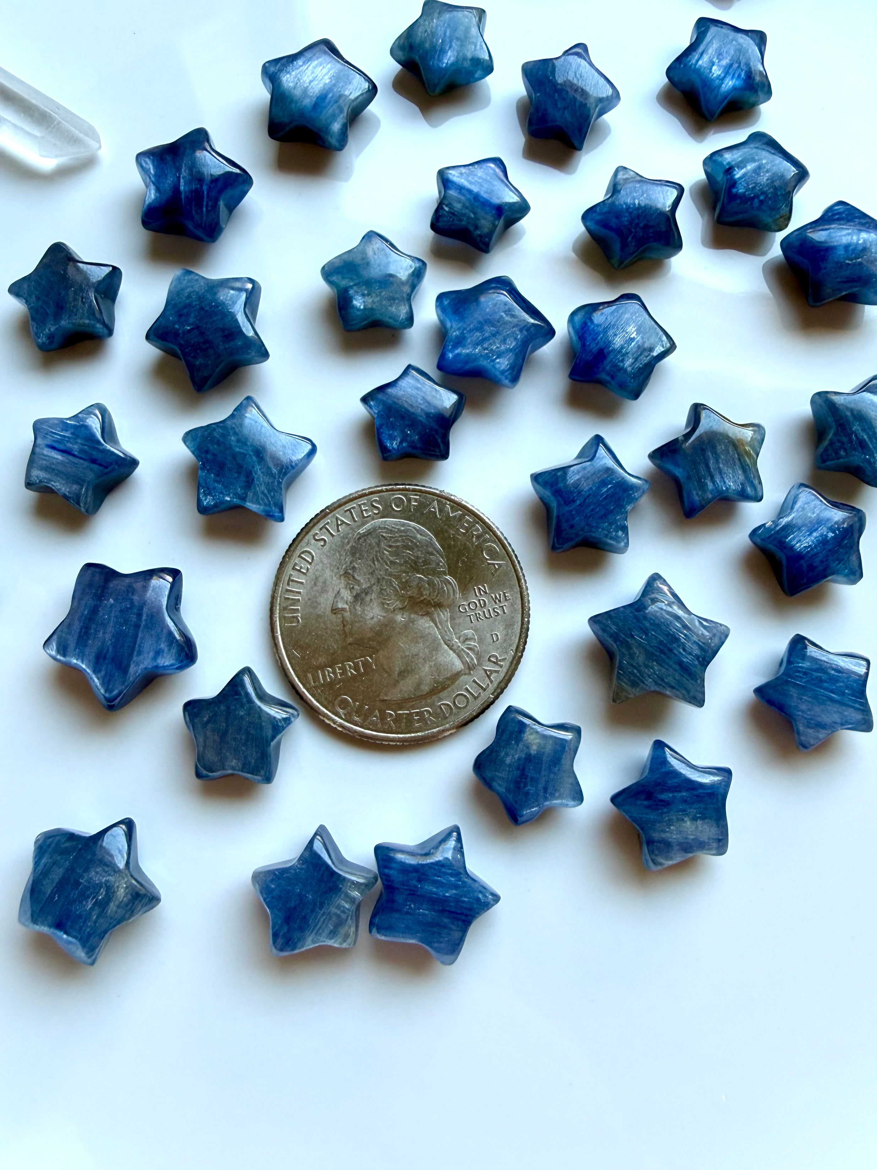 Mini Blue Kyanite star carvings shown with a US quarter for scale for meditation, energy alignment, and spiritual practice