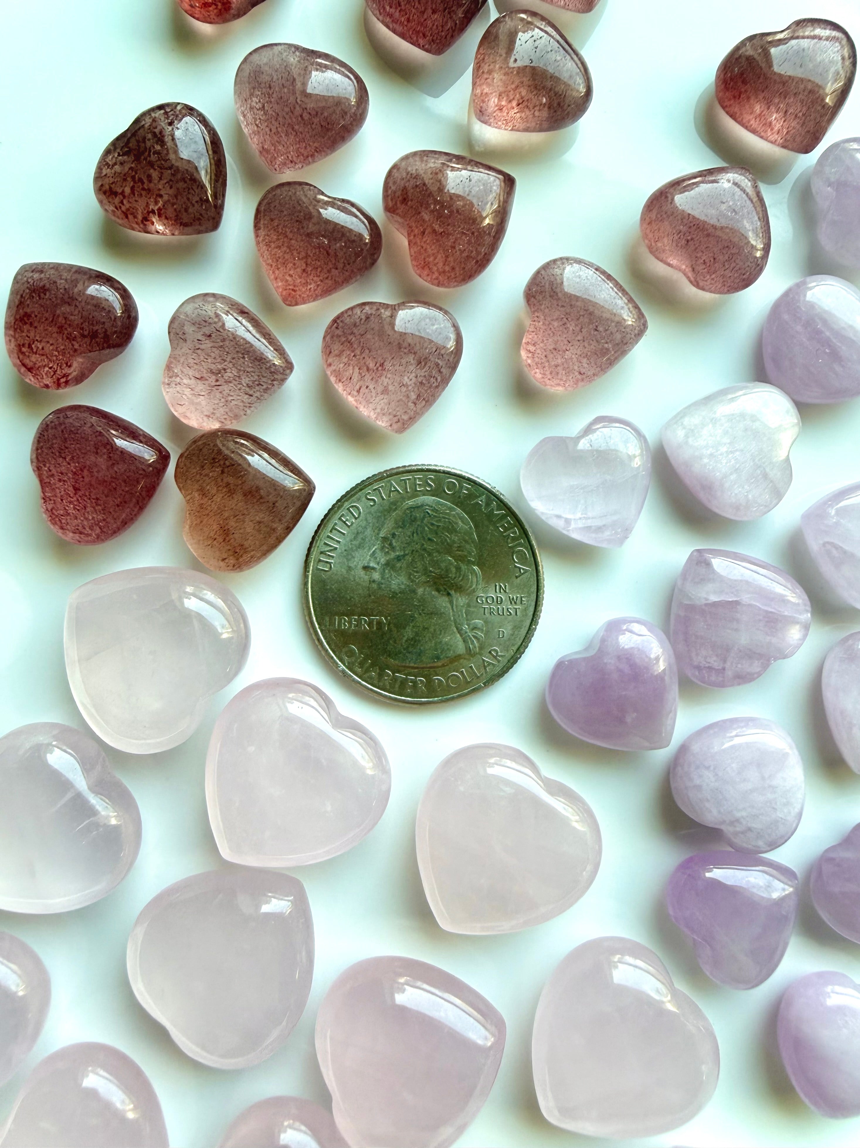 Mini crystal hearts with US quarter for scale showing size of rose quartz, strawberry quartz, and kunzite heart stones