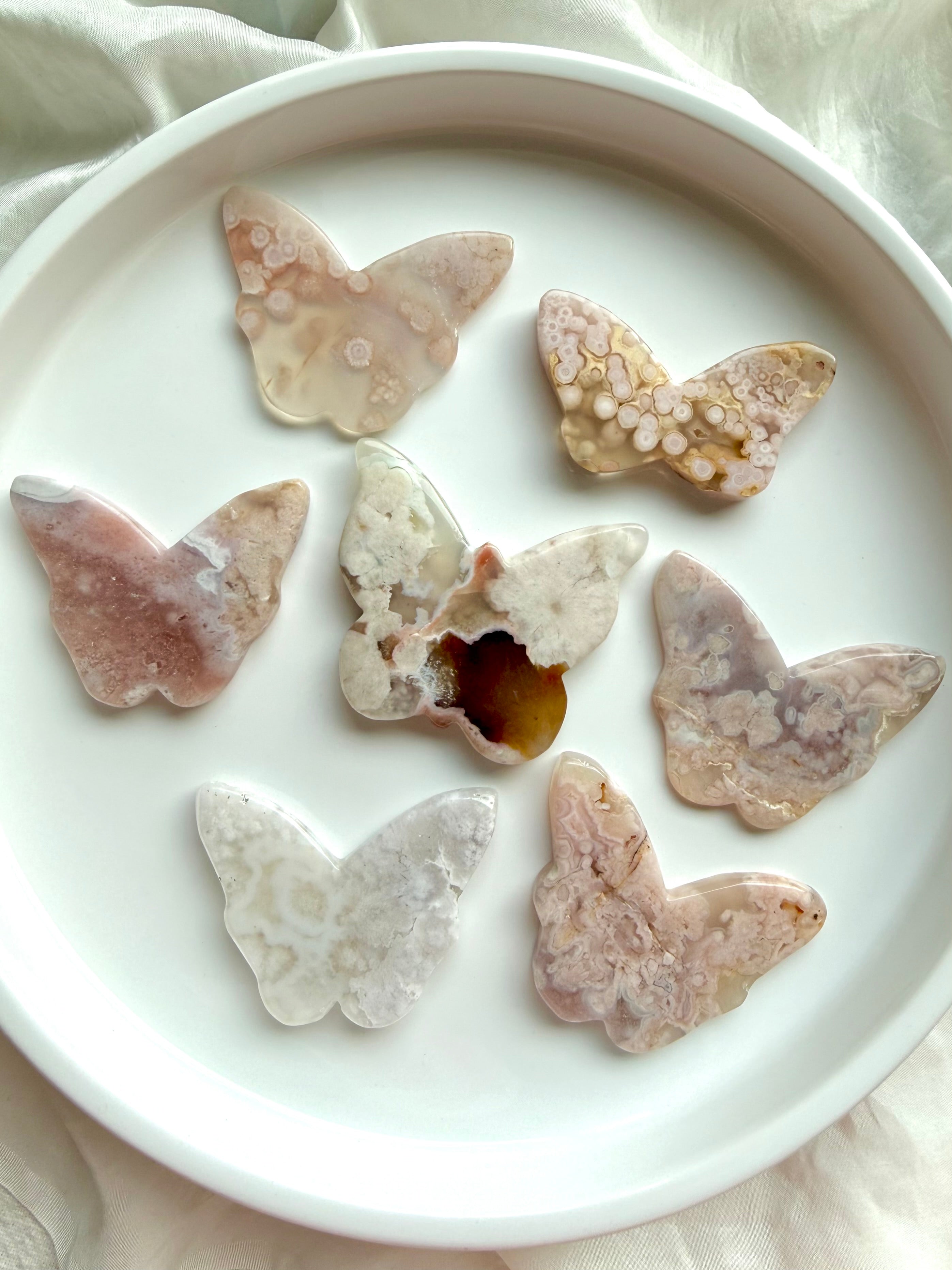 Back view of Flower Agate butterfly crystal carvings showing natural blossom patterns and agate banding