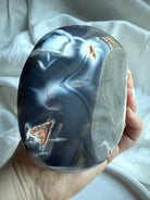 Orca Agate offering bowl showing deep blue-grey banding with a natural exposed druzy pocket and polished edges — grounding crystal bowl for calm, protection, and ritual use.