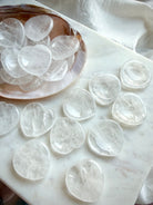 clear quartz heart worry stones on dish on marble for clarity energy and chakra healing