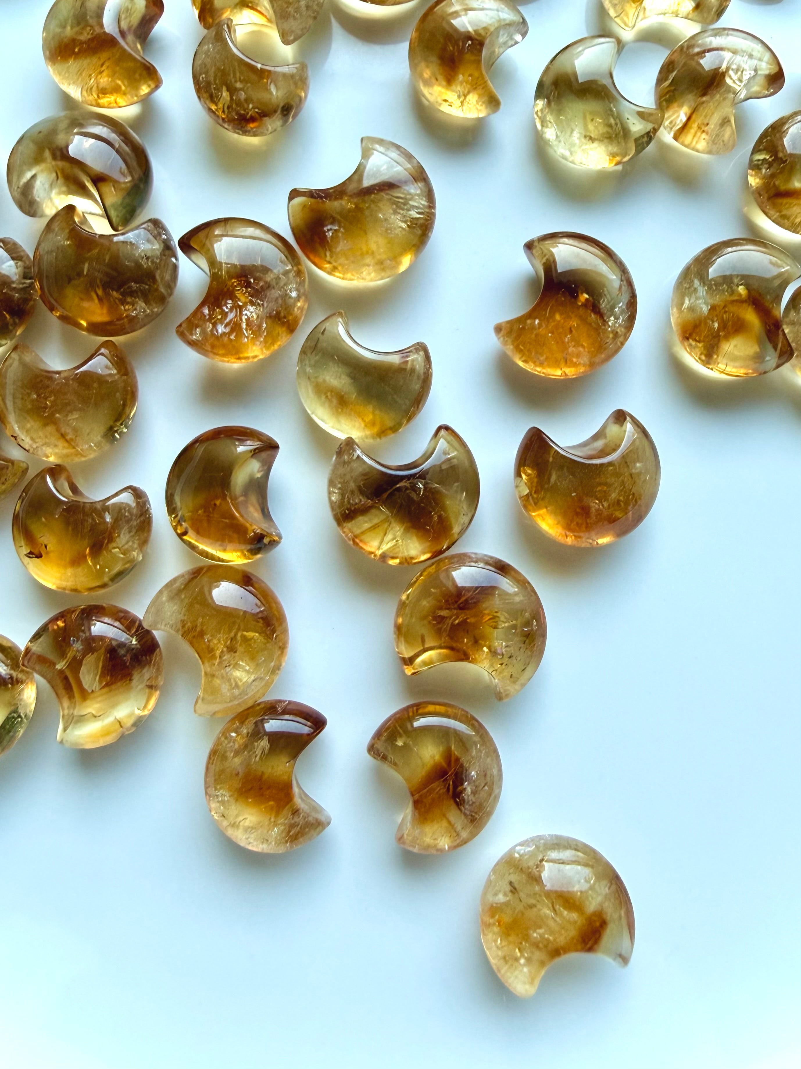 High-clarity Mini Citrine moons with warm amber, honey-gold and champagne tones on a white background