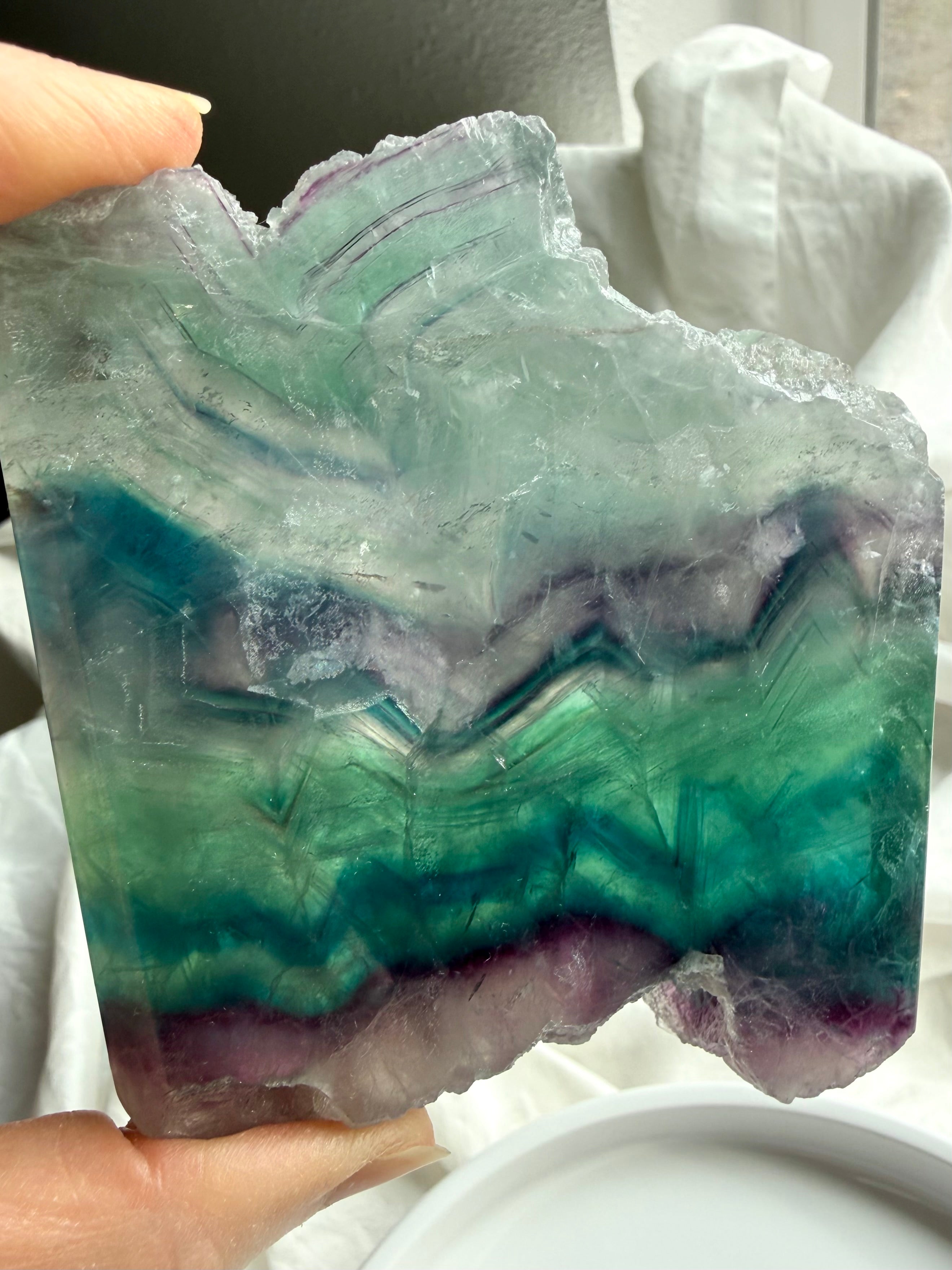 One of a kind fluorite slab shown in hand for size reference