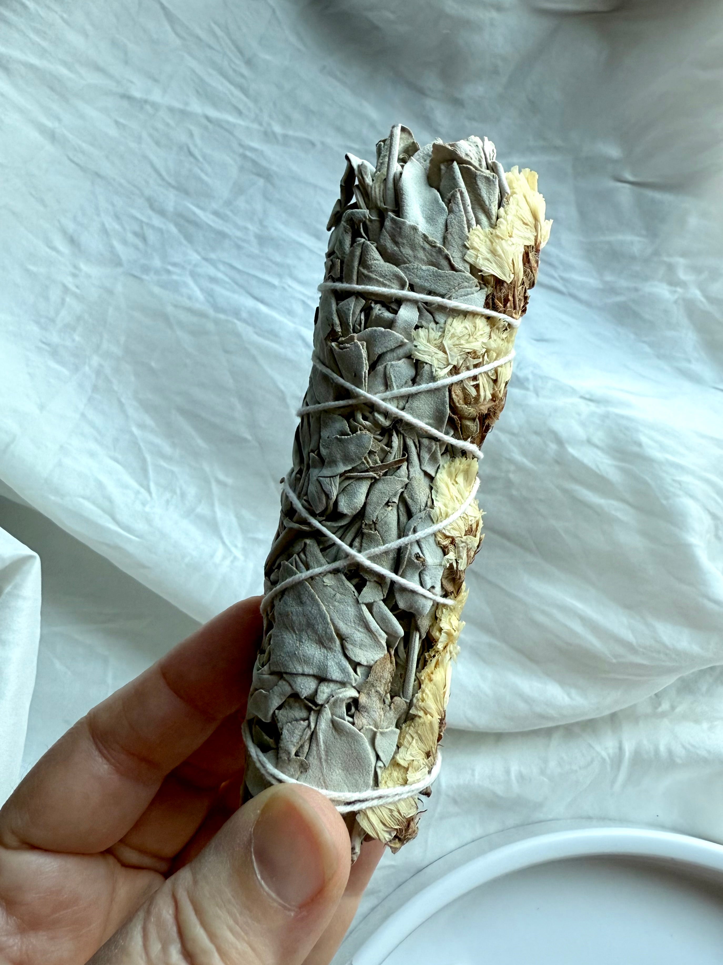 Side view of our ethically sourced white sage bundle with white statice flower for sacred smudging practice