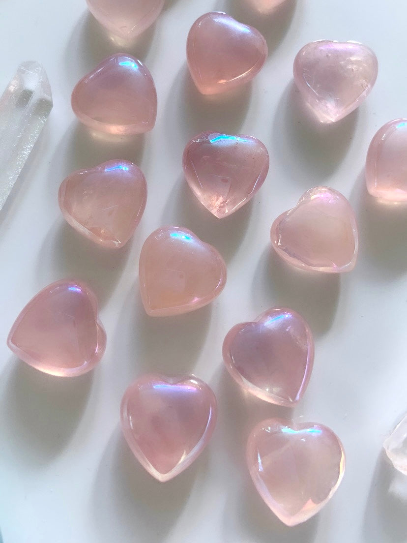 Array of glowing mini angel aura rose quartz hearts on a white background — radiant pink crystals for love, emotional healing & heart chakra energy